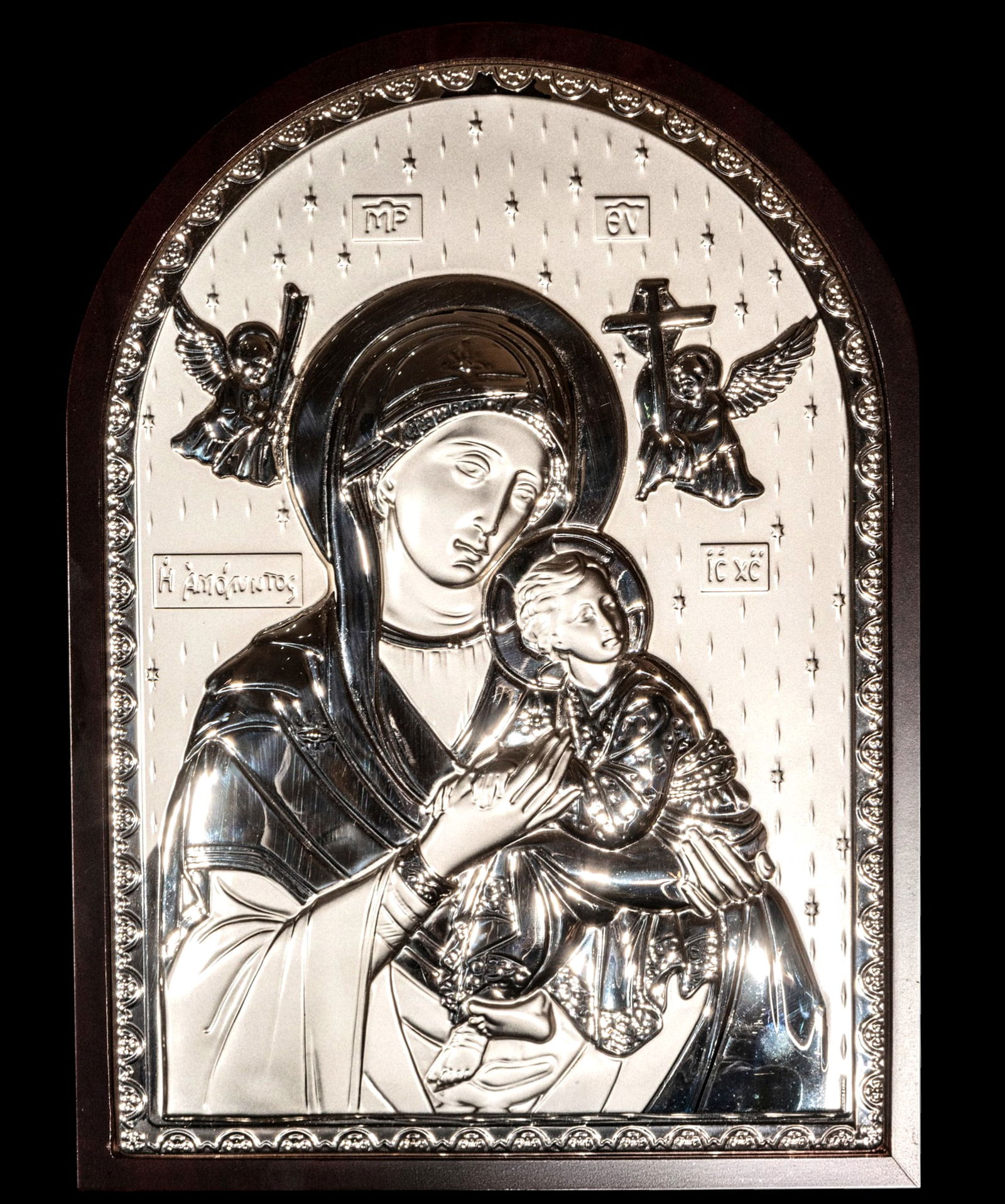 Icon of the Virgin and Child, Greek Orthodox School, 20th Century, with seal: Repoussé silver on a wooden support. Measures 30 x 21 cm and 34 x 23 cm. Icon of the Virgin and Child in the Orthodox tradition, made with a silver relief plaque on a wooden support, with a dotted ba