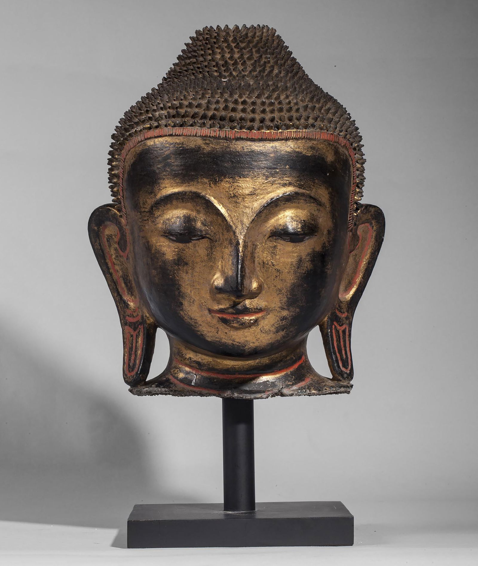 Buddha head with a youthful beauty and serene expression, displaying fine curls covering the cranial (1 of 4)