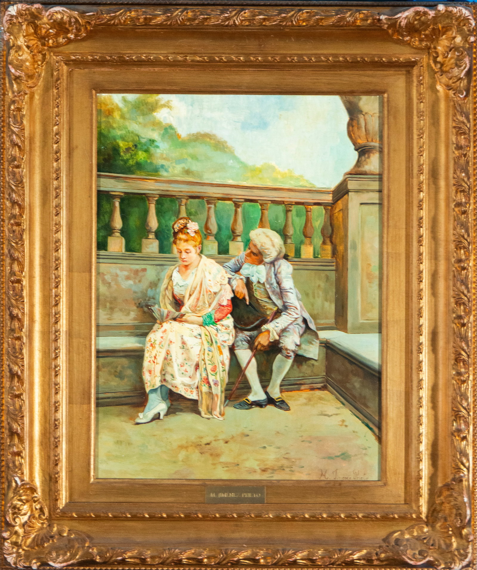 Courtship. Spanish School. 19th Century: Oil on panel. In this gallant genre scene, an elegantly dressed lady in a floral dress, shawls, and Rococo hairstyle sits on a stone bench, holding a fan. At her side, a gentleman in a courtly attitud