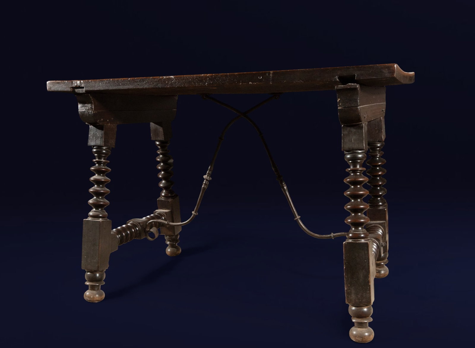 Walnut table with turned legs. Spanish School. 17th century.: Carved walnut wood. Dimensions: 80 x 113 x 66 cm. Rectangular table with a thick plank top and a structure reinforced by iron crossbeams. The legs, turned in a "lens" or spindle shape, rest on square