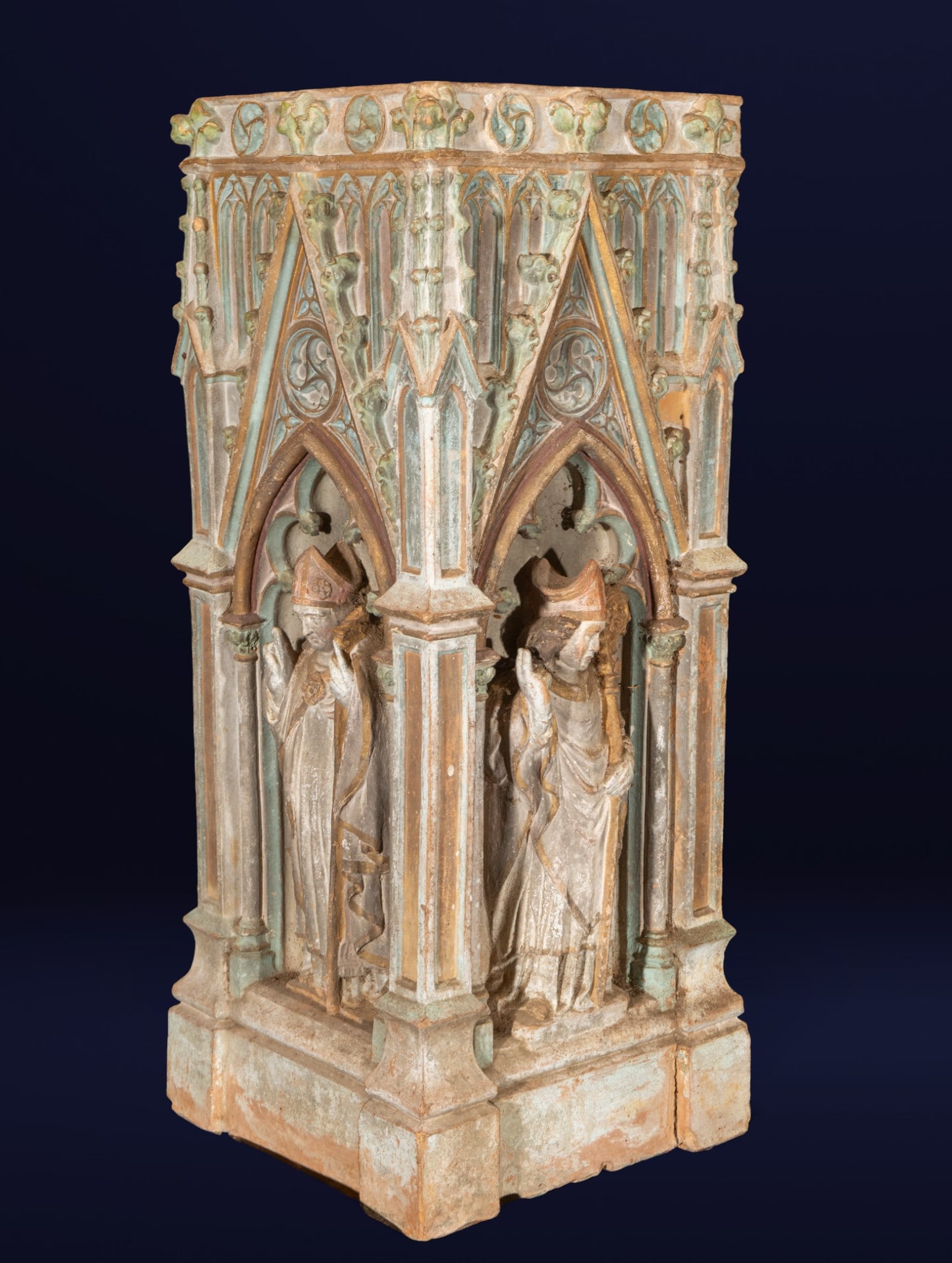 Neo-Gothic pedestal. European school. 19th century.: Polychrome terracotta. Measures 81 x 42 x 25 cm. Neo-Gothic style base with an octagonal structure, decorated with pointed arches and episcopal figures in relief, framed by canopies and tracery of med