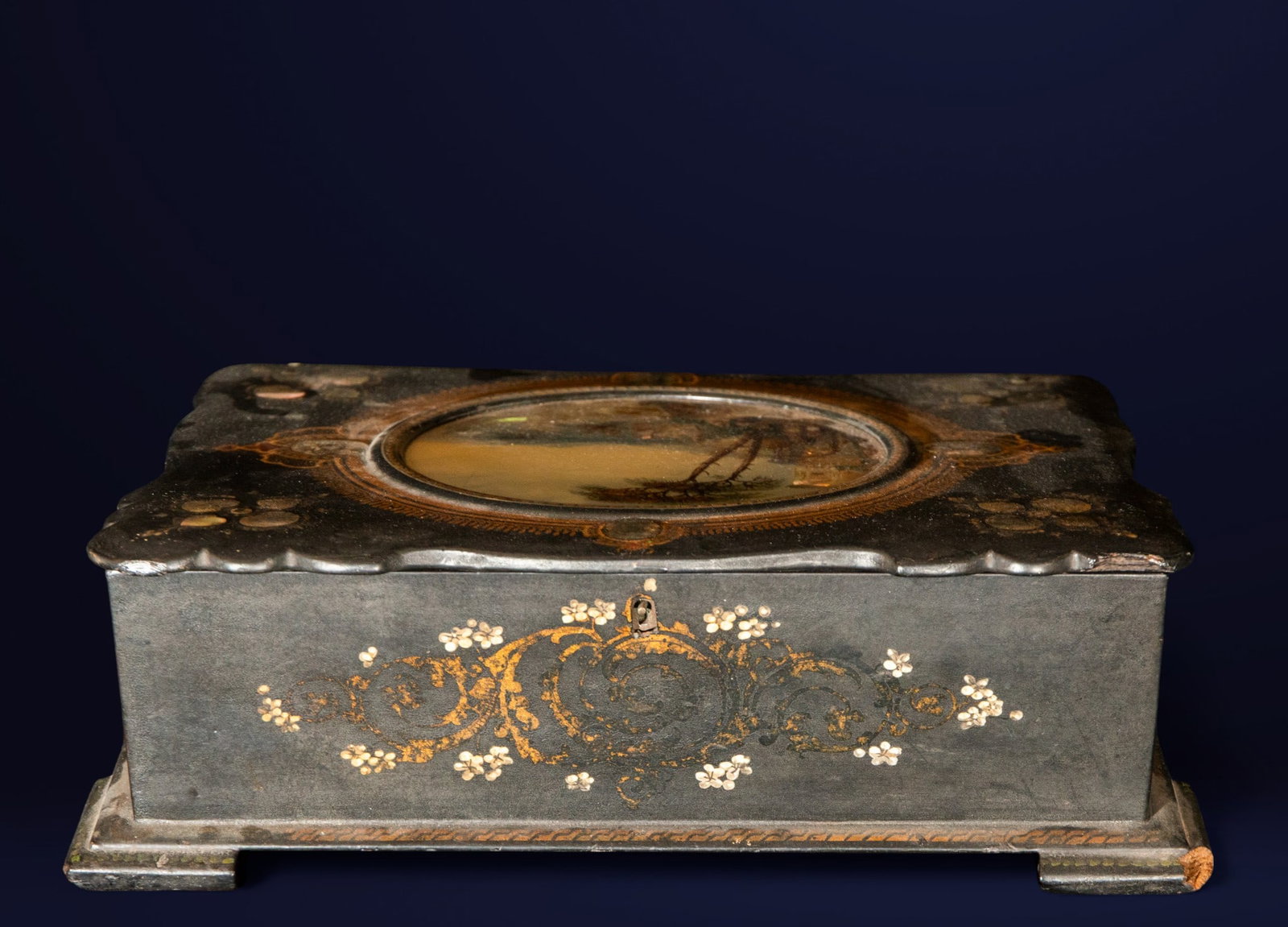 Sewing box with mother-of-pearl inlay. European school. 19th century.: Ebonized wood inlaid with mother-of-pearl and gilded floral motifs. Measures 35 x 27 x 11 cm. Rectangular box with an oval lid decorated with a landscape painted under glass. The interior features com
