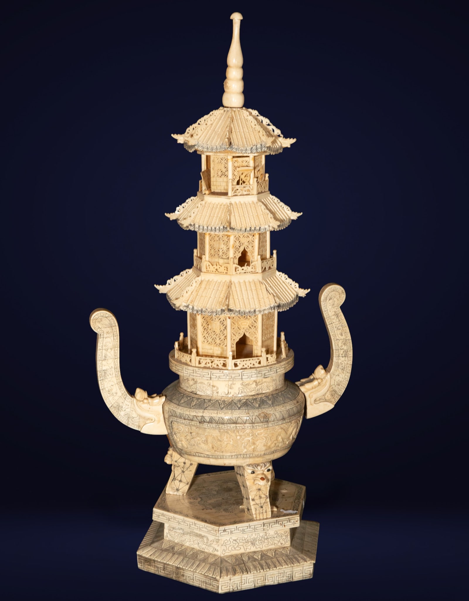 Large Chinese pagoda made of bone. Chinese School. 20th century.: Carved bone with a three-tiered architectural structure. Measures 83 x 41 x 30 cm. Pagoda decorated with filigree, inscriptions, and mythological figures, mounted on an octagonal pedestal with zoomorp