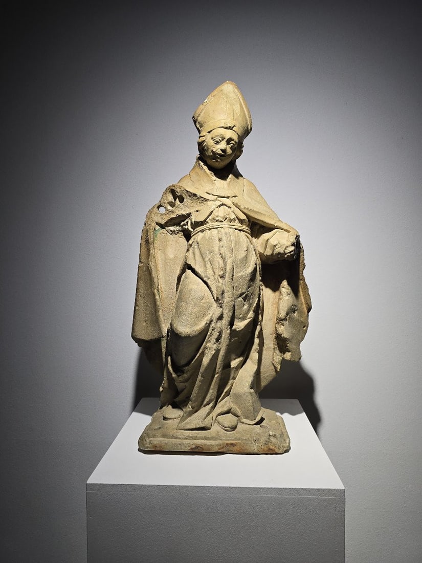 French Gothic stone sculpture of a bishop – 15th century: A stunning 15th-century French Gothic sculpture depicting a bishop, adorned with remnants of its original polychromy in shades of blue and green. This piece of great decorative value showcases the exp