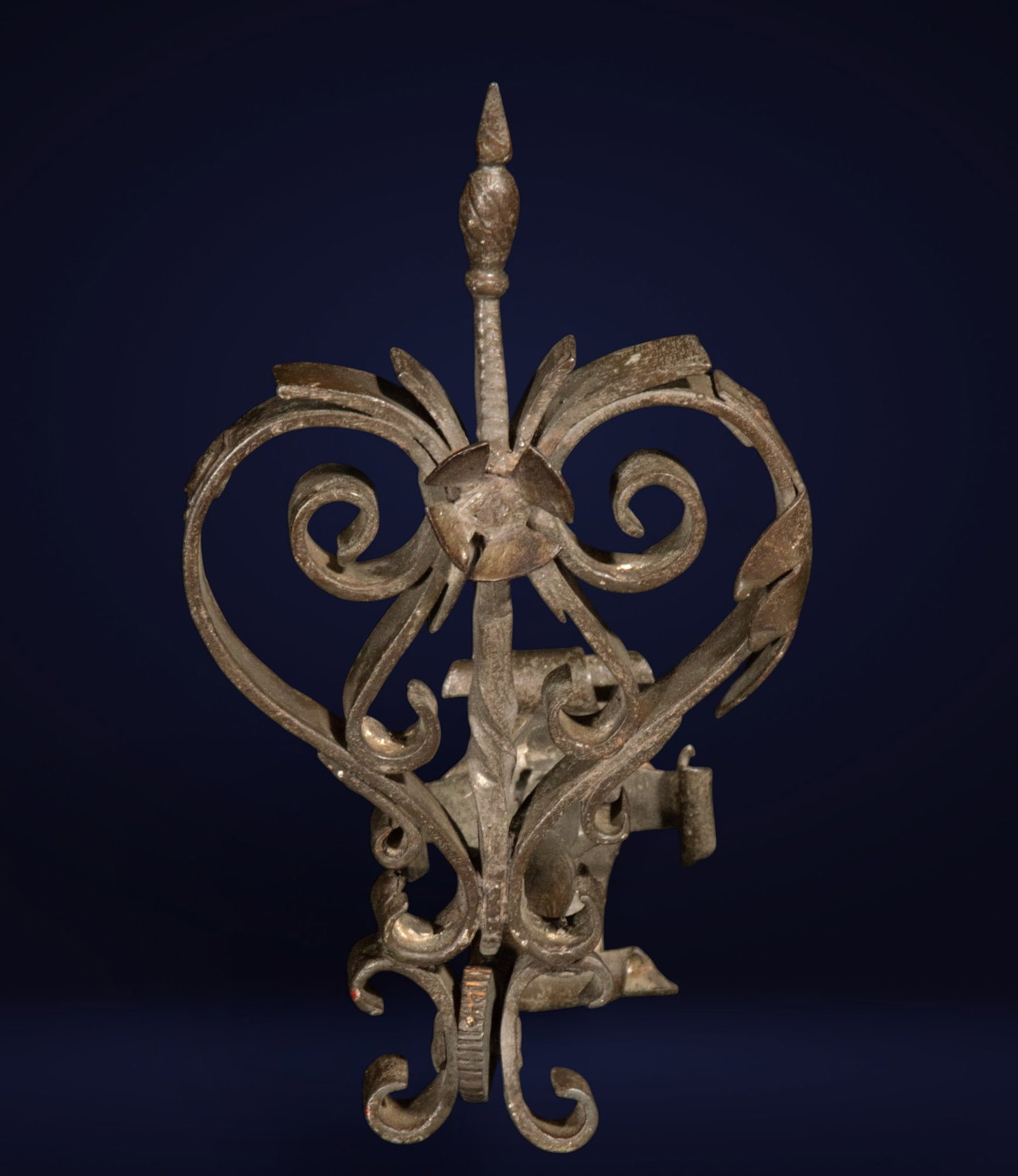 Wrought iron wall light with plant motifs. Spanish School. 19th century: Wrought iron. Ornamental piece of artistic forging in the form of a large volute crowned by a spearhead, flanked by symmetrical scrolls with stylized leaves. The structure, possibly belonging to a lan