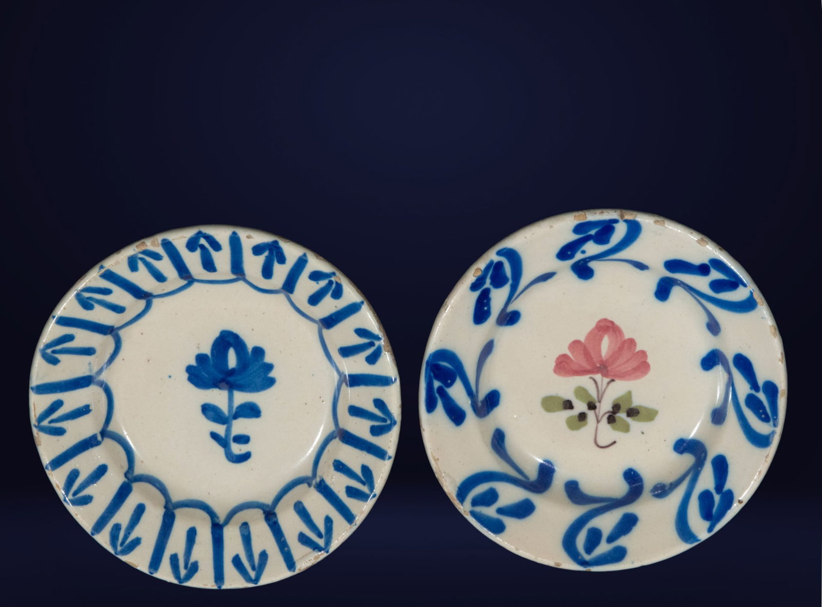 Group of plates. Spanish Folk School. 19th Century: Hand-painted glazed ceramic. Dimensions: 18 x 18 x 3 cm. Set of decorative plates with floral motifs in blue and pink on a white background. The spontaneous brushstrokes and ornamental arrangement are