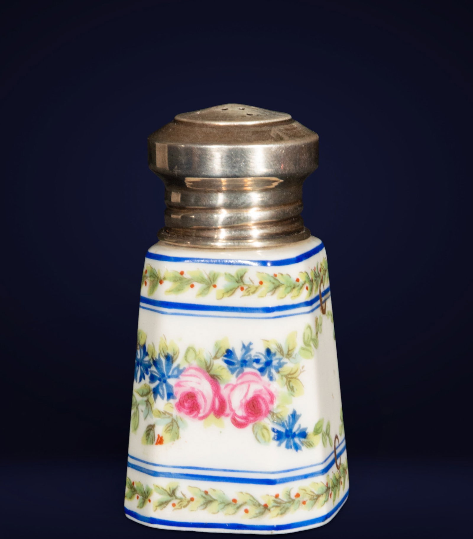 Limoges porcelain salt cellar with floral decoration and silver finial. French school. 19th century.: Conical salt cellar in French Limoges porcelain, finely hand-decorated with floral garlands in shades of blue, green, and pink. Plain silver mounting. Dimensions: 8 x 5 x 5 cm. A representative piece