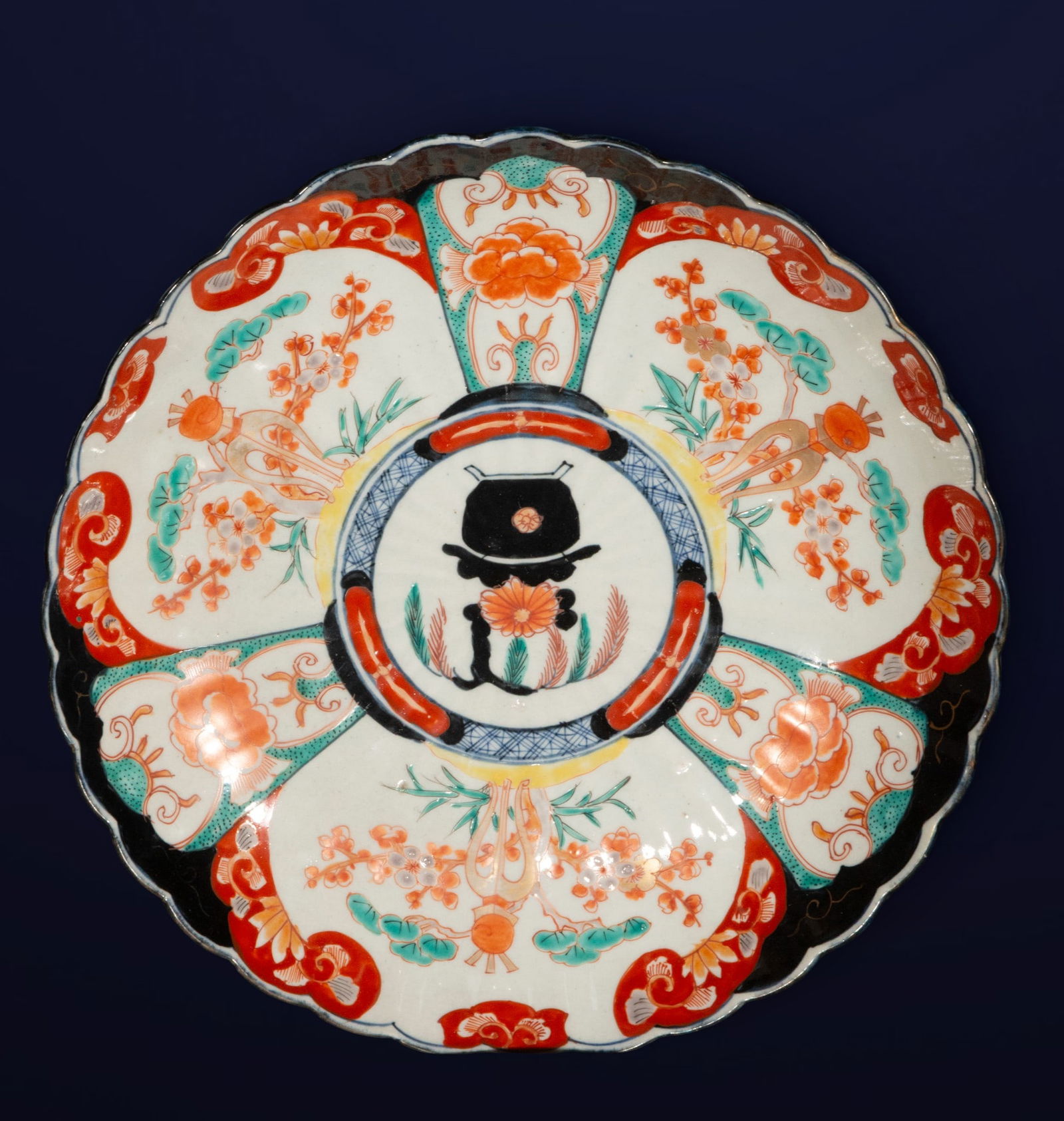 Imari porcelain plate with floral and heraldic decoration. Japanese school. 19th century.: Circular Japanese Imari porcelain plate, decorated in blue, red, and gold with flowers, foliage, and a central emblem. Dimensions: 4 x 32 x 32 cm. A traditional 19th-century Japanese export piece of r