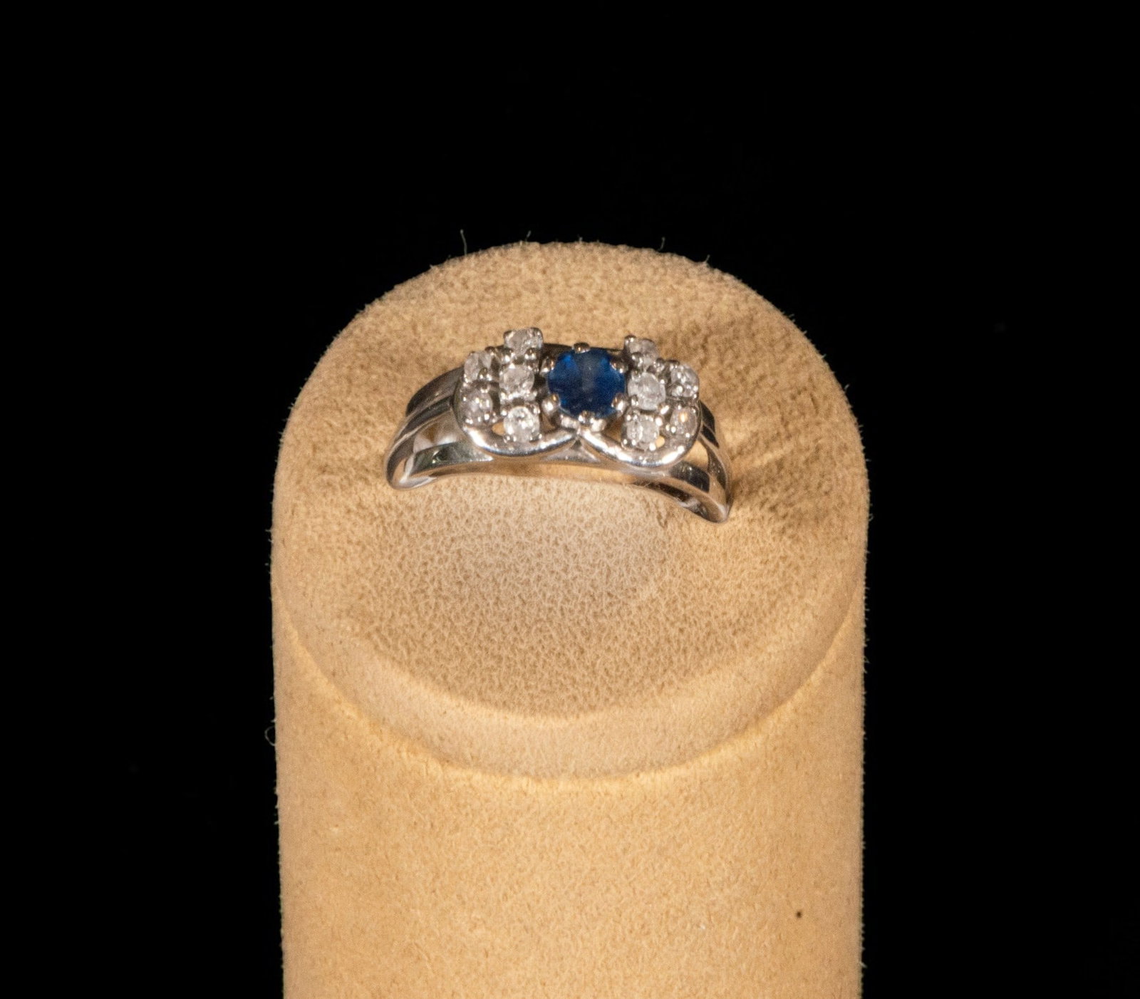 White gold ring with brilliant-cut diamonds in claws and brilliant-cut sapphire in claws, weight: A white gold ring with brilliant-cut diamonds in prongs and a brilliant-cut sapphire in a prong setting, weighing 6.11 grams. The piece features an open, yet substantial, upper motif, dominated by a c