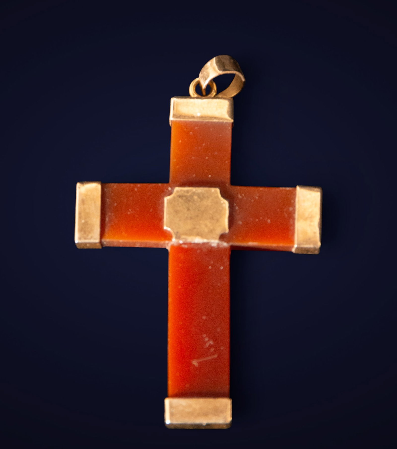 Agate and 18-karat gold cross in a box. European School. 19th century.: Agate and 18-karat gold. Measurements: 6 x 4 x 0.4 cm. Latin cross crafted in reddish agate, with 18-karat gold ends and settings. The smooth surface of the semiprecious stone is enhanced by the warmt