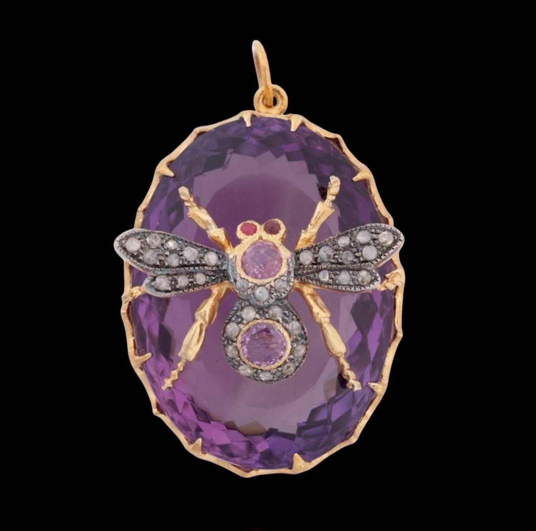 Oval pendant with amethyst, pink sapphires and diamonds: Oval-shaped pendant crafted in 925 sterling silver with a gilt finish and a 14-karat gold bail. The pendant features a large amethyst, weighing approximately 30 carats, adorned on the front with openw