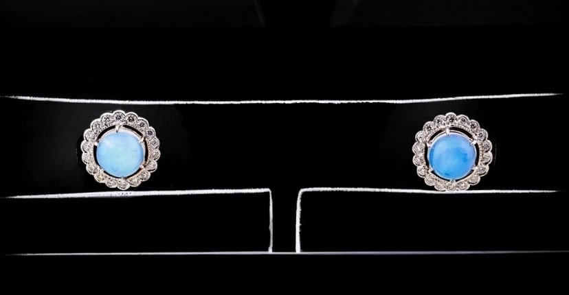 Pair of earrings with opals and diamonds: Pair of earrings crafted in 14-karat gold, featuring a classic design with a central opal surrounded by brilliant-cut diamonds. Each earring features one opal, totaling two opals with an approximate c
