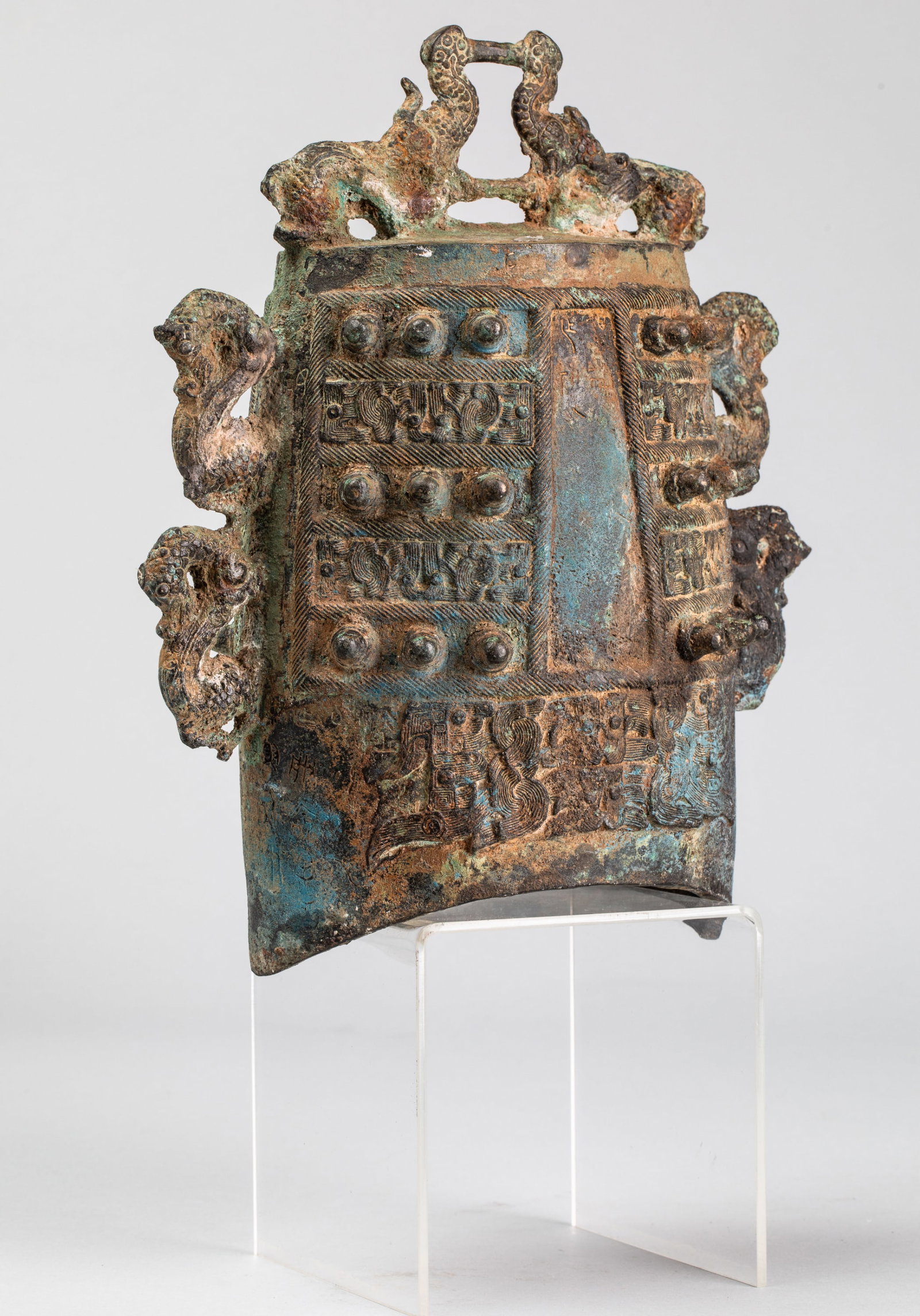 Exceptional Chinese Imperial Ceremonial Bell Shang cylindrical "Bo" China. Western Zhou - Former: Exceptional Shang Chinese Imperial Bell, cylindrical "Bo" with an ovoid section, with a zoomorphic spike depicting two facing elephants and, on either side of the rim, two pairs of chimeras.
