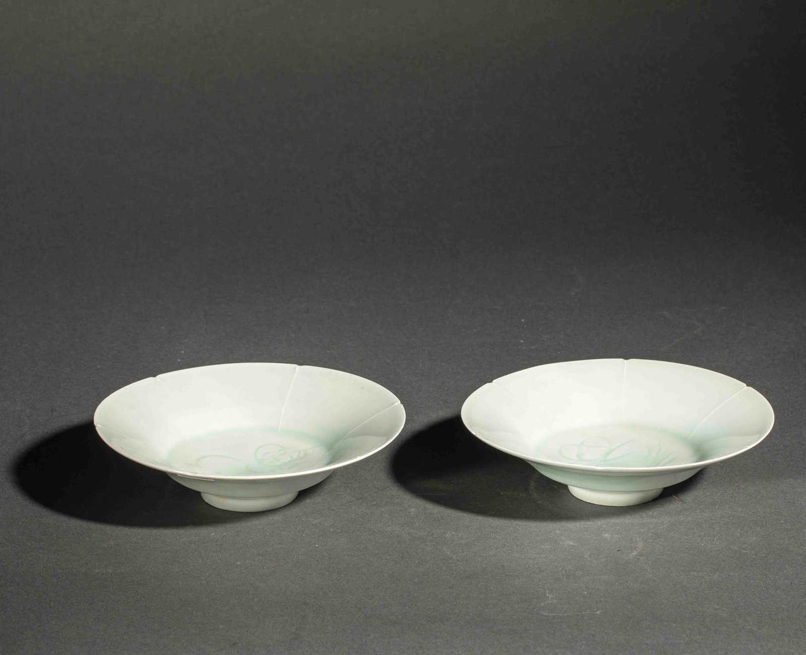 Pair of fine porcelain Qinbaï cups with incised decoration under a translucent monochrome celadon: Porcelain. Song Dynasty. 960–1279. Lot in international warehouse (outside the EU). For shipments to the European Union, import duties and/or taxes will apply and are the responsibility of the buyer