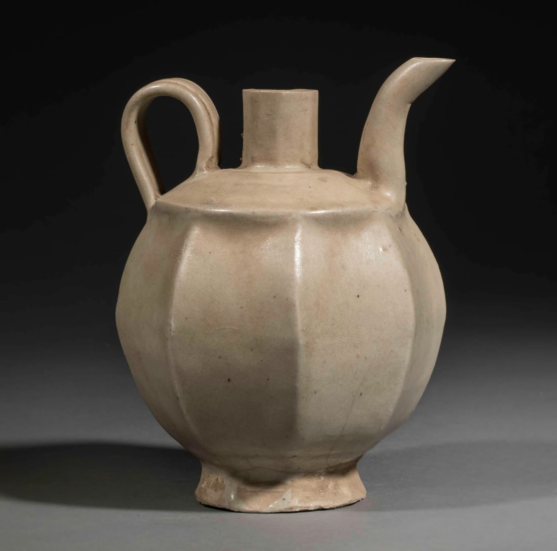Octagonal-bodied jug with a handle. Qinbaï porcelain with monochrome glaze, beige cecidon.: Jug with octagonal body and handle. Qinbaï porcelain with monochrome glaze, beige cecidon. Porcelain. Song Dynasty. 960 to 1278. Height 15 cm x 11 cm. Small chip on the spout. China - Tibet - Ori