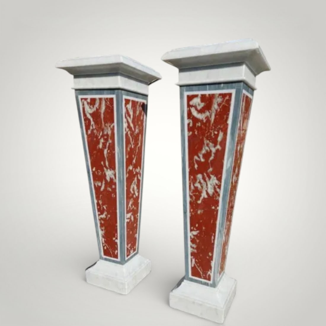 Pair of marble pilasters, Italy, 20th century: Carrara Statuario white marble and French red marble. Dimensions: height 125 cm; upper base 35 x 35 cm (each). An elegant pair of sculptural pilasters crafted from a refined combination of Carrara Sta
