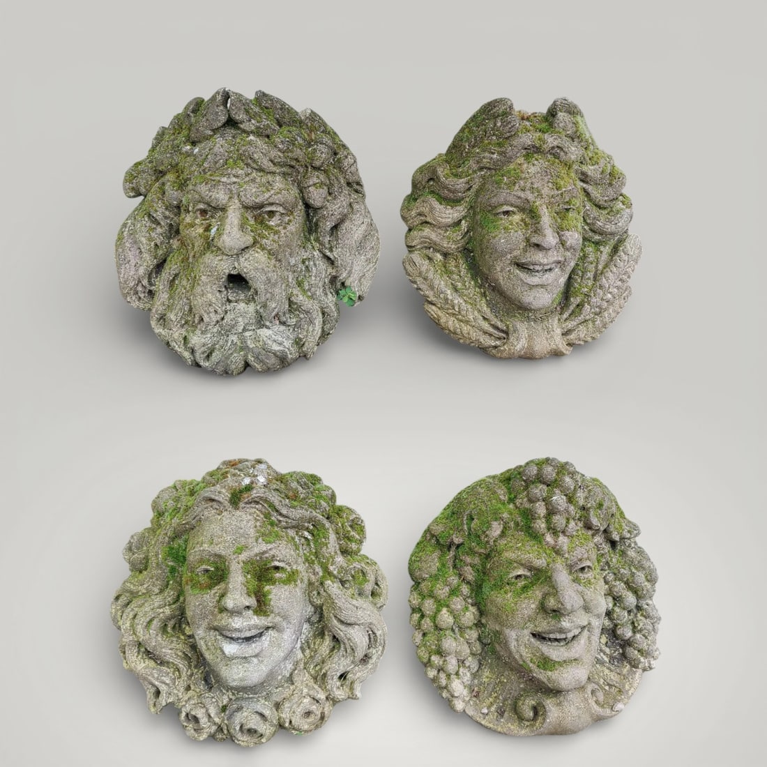 Set of four stone mascarons from Vicenza, Italy, 20th century: Carved Vicenza stone. Dimensions: 34 × 38 × 20 cm (each). This collection comprises four sculptural mascarons carved from Vicenza stone, originally from a Venetian collection. The pieces are notable
