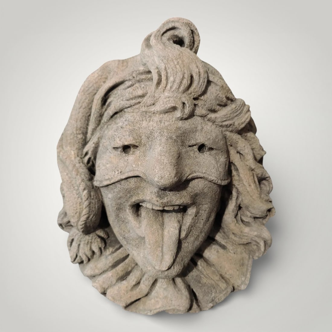 Vicenza stone figurehead representing a carnival jester, Italy, 20th century: Carved Vicenza stone. Dimensions: 33 × 38 × 20 cm. Spectacular Venetian Carnival mask representing Pantalone, the quintessential elderly, avaricious, and extravagant merchant, an emblematic figure o