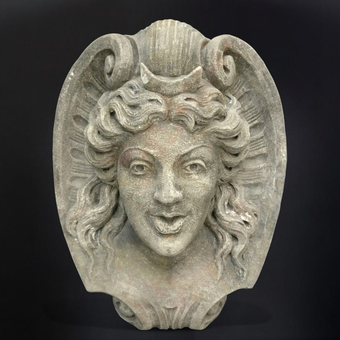 Vicenza stone figurehead representing the goddess Diana, Italy, 20th century: Hand-carved Vicenza stone. Dimensions: 45 × 38 × 20 cm. Magnificent mascaron representing Diana—deity of the woods, the hunt, and the moon, assimilated to Artemis—recognizable by the crescent mo