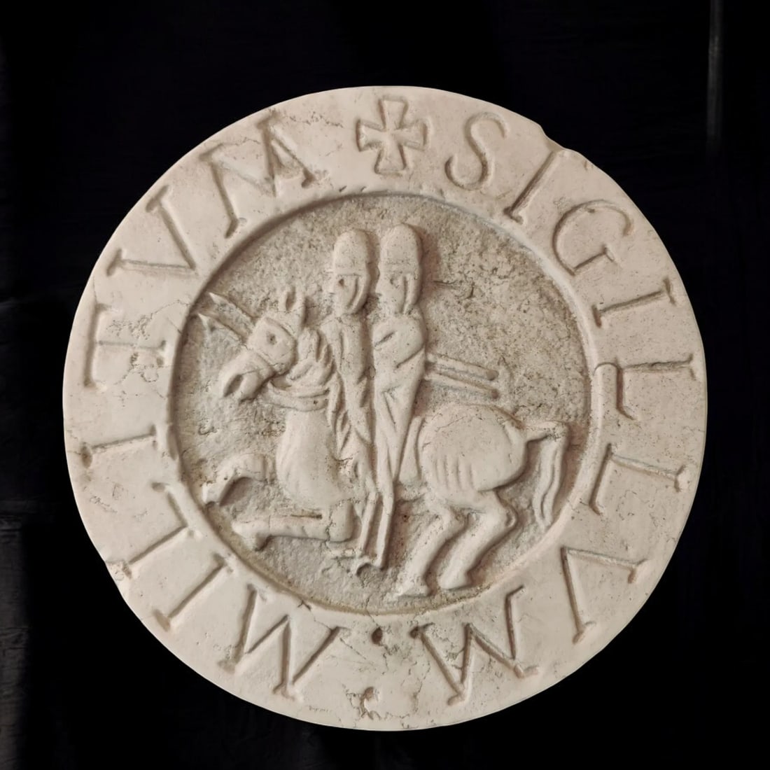 Istrian marble seal with Knights Templar, Italy, 20th century: Carved Istrian marble. Dimensions: Ø 32 × 6 cm. Circular seal depicting two Knights Templar riding the same horse, a traditional symbol of shared poverty, accompanied by the Latin motto “Sigillum 