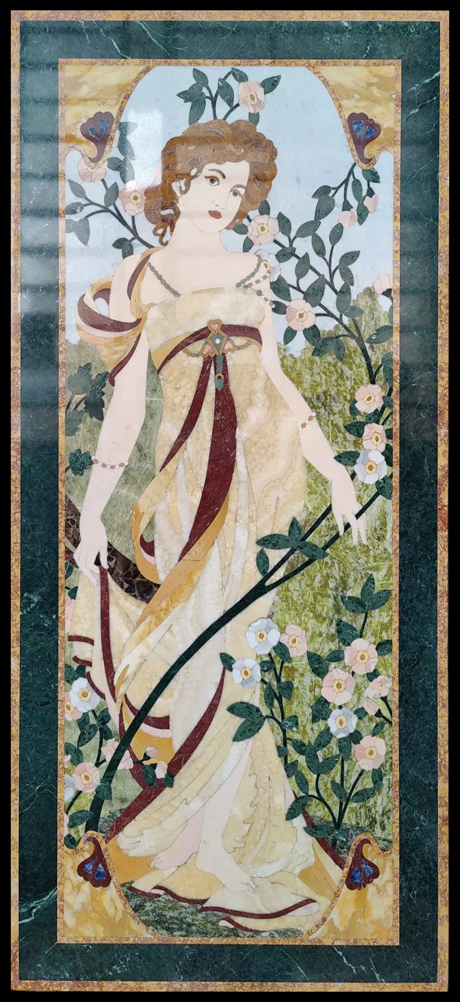Marble panel following designs by Alfons Mucha (1860-1939), Italy, 20th century: Polychrome marble inlaid on a travertine base. Dimensions: 179.5 × 80.5 × 3 cm. Refined panel depicting an elegant woman surrounded by floral ornamentation, featuring excellent intarsia and splendid