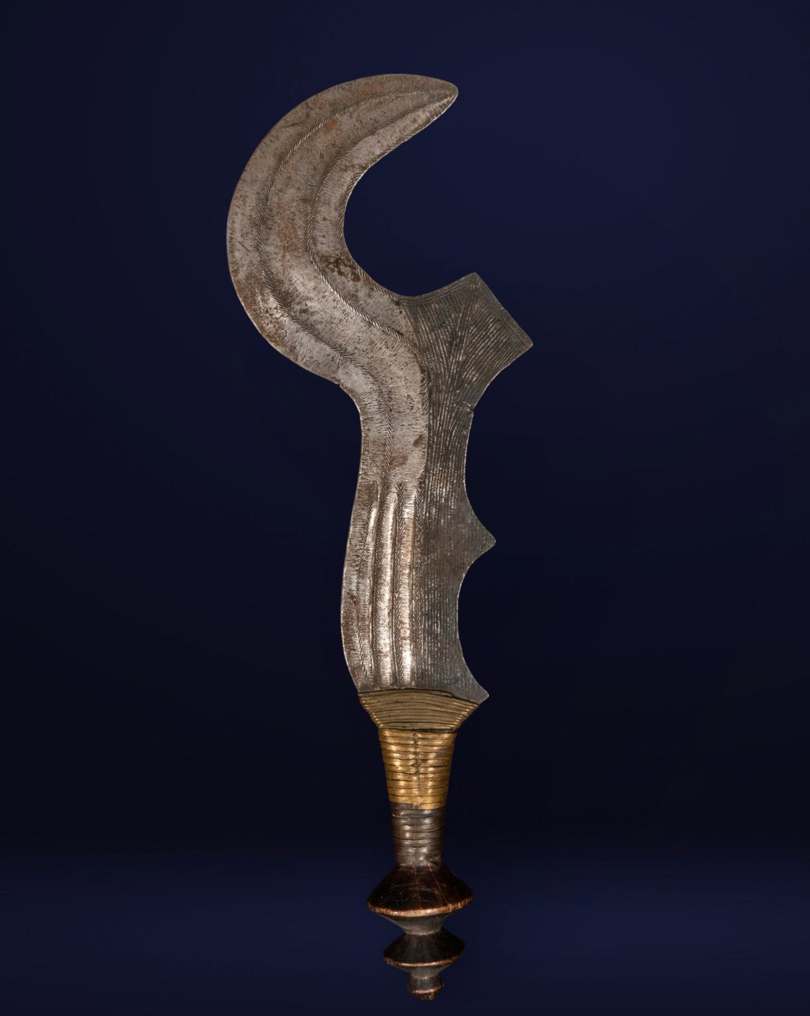 African iron coin, early 20th century - African Art: Chiseled metal with a turned wooden base. Measures 53 x 17 x 7 cm. A vertical piece with a strong sculptural presence, formed by a cut and engraved metal sheet with a curved profile and semicircular e