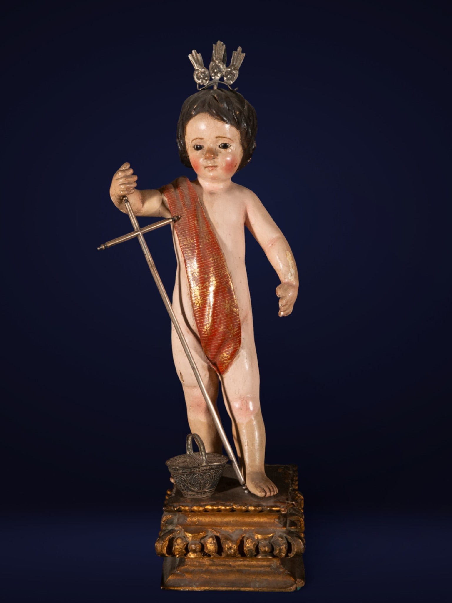 Child Jesus, attributed to José de Risueño, Granada school of the 18th century, elements in silver: Carved, polychrome wood, with silver cross, crown and basket. Measures 51 x 14 x 13 cm.