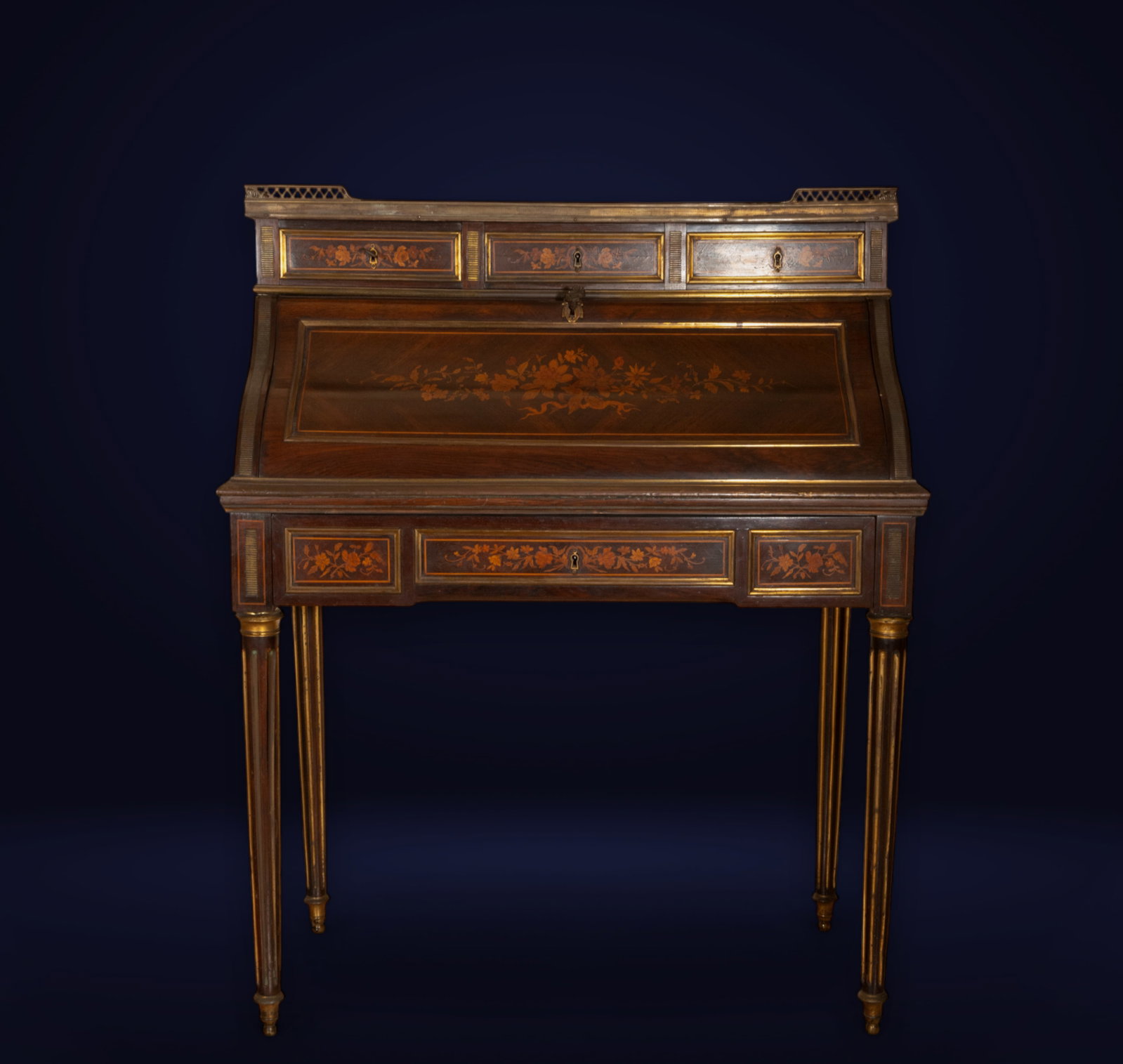 Louis XVI style bureau with fine wood marquetry and bronze trim, France, 19th century: Carved wood, marquetry, and bronze appliqués. Dimensions: 106 x 46 x 89 cm.