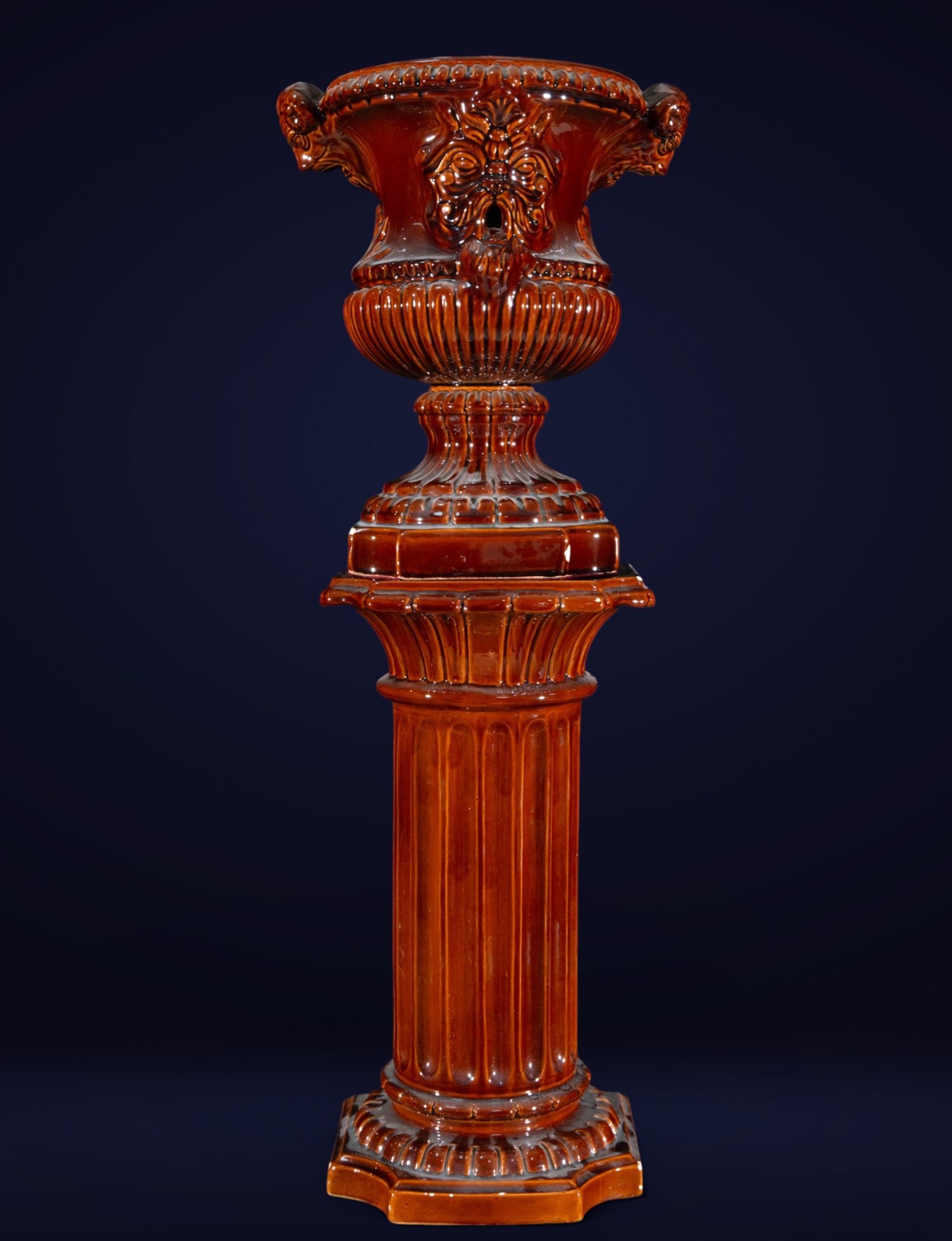 Ornamental cup with majolica pedestal, historicist style, 20th century: Glazed porcelain, Mallolica style. Measures 86 x 32 x 25 cm. The set comprises a fluted pedestal and a large ornamental cup raised on a molded base, all adorned with a repertoire of gadroons, scrolls,