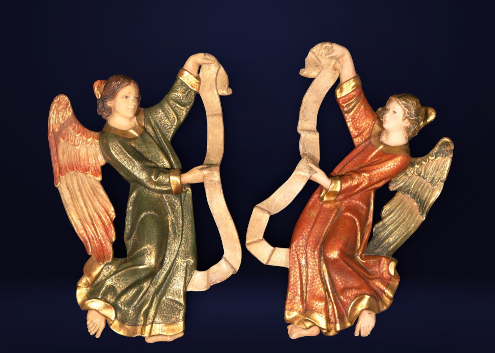 Pair of angels carrying a phylactery, Spanish school, 20th century: Carved, polychromed and gilded wood. Measures 74 x 50 x 9 cm.