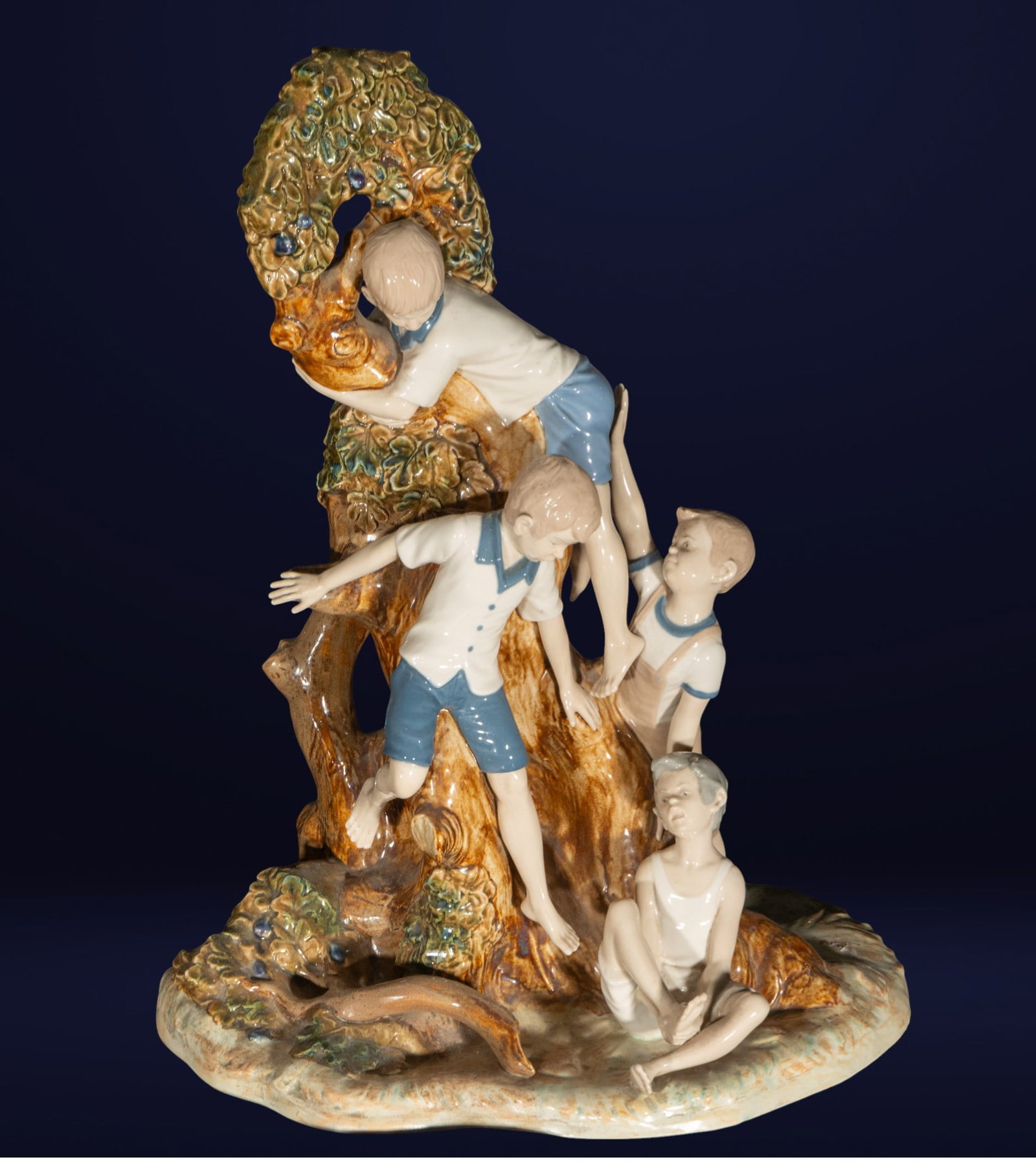 Enameled porcelain sculpture, Children playing in a tree. 20th century: Glazed porcelain sculpture. Dimensions: 59 x 43 x 28 cm. A dynamic scene featuring five children playing around a tree trunk, in lively and varied poses: climbing, sitting, or leaning against each oth