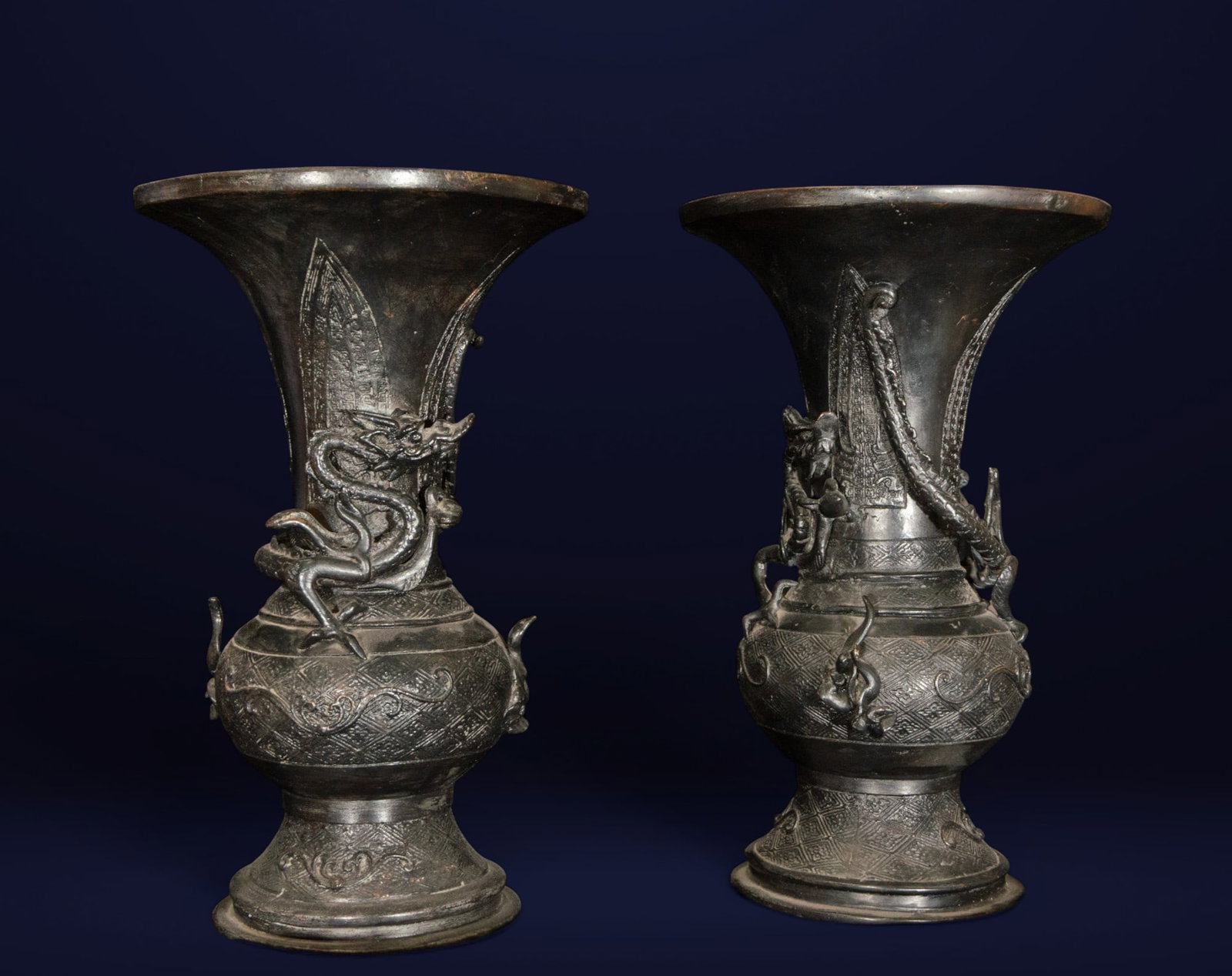 Pair of Chinese vases with dragons. Chinese School. 19th century.: Patinated bronze. Pair of Chinese Hu-shaped vases, richly ornamented with high-relief motifs of ascending dragons, symbols of power, strength, and imperial protection. The surface features an incised 