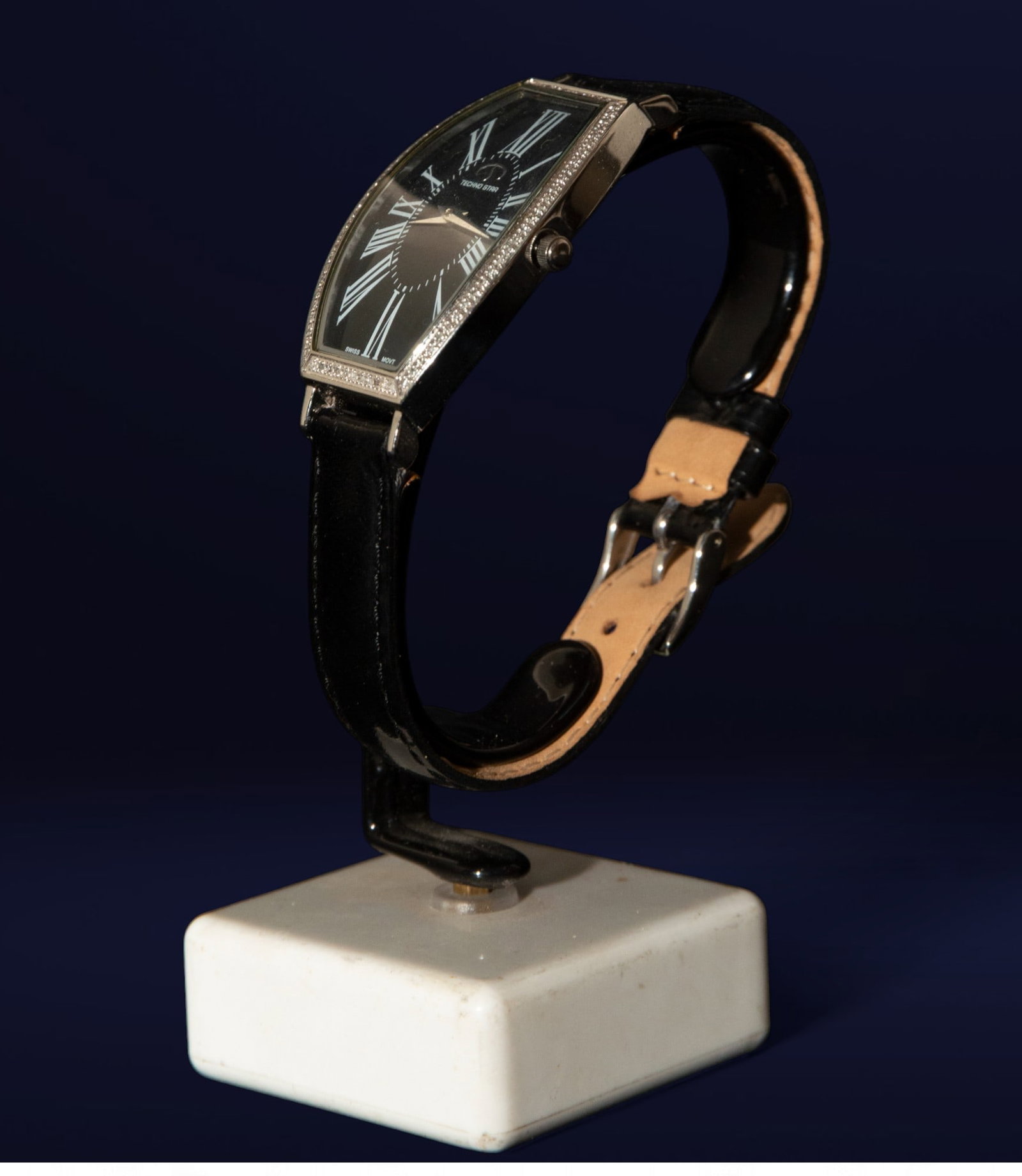 Tecno Star wristwatch with diamonds and a black leather strap. Swiss School. 20th century.: Steel, diamonds, and leather. Measurements: 4 x 3 x 1 cm. Contemporary wristwatch with an oval case set with diamonds and a black dial with white Roman numerals. The black leather strap provides a sob