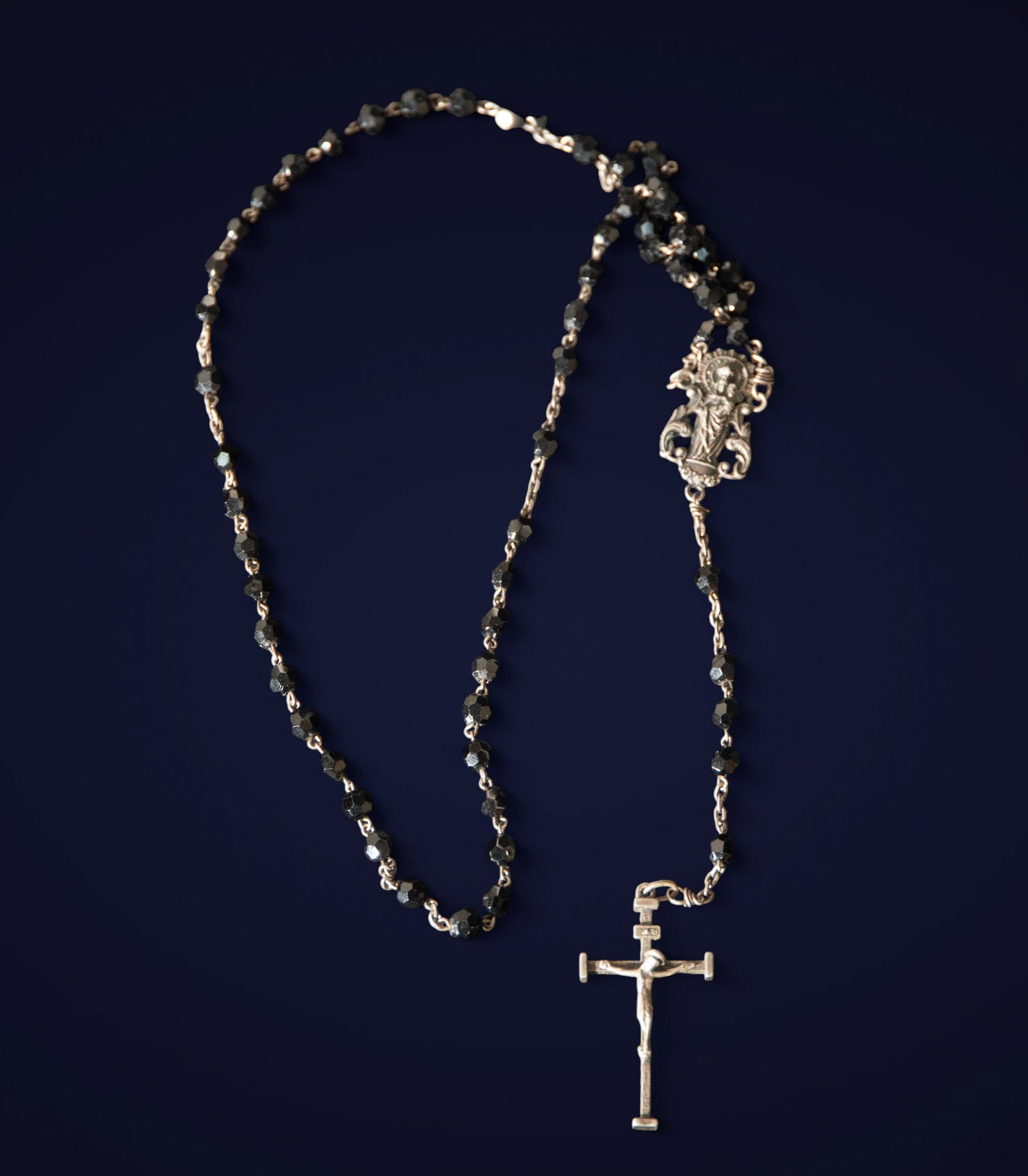Jet and silver rosary. Spanish School. 19th century: Jet and silver. Measurements: 5 x 2.5 x 1 cm. Rosary with faceted jet beads connected by silver links, with a precious metal crucifix. The combination of the jet's dark sheen with the silver's luminos