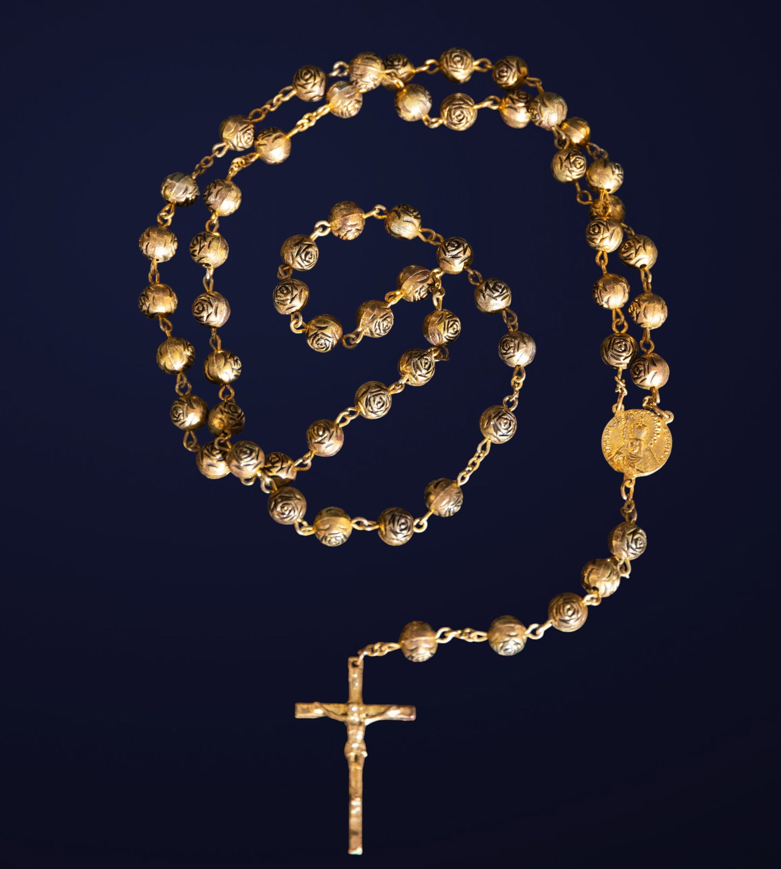Bronze rosary. Spanish School. 19th century: Cast bronze. Dimensions: 4.5 x 3 x 1 cm. Rosary with spherical beads crafted with embossed motifs, attached to a simple crucifix. The dark metallic finish and the robustness of the material give it an