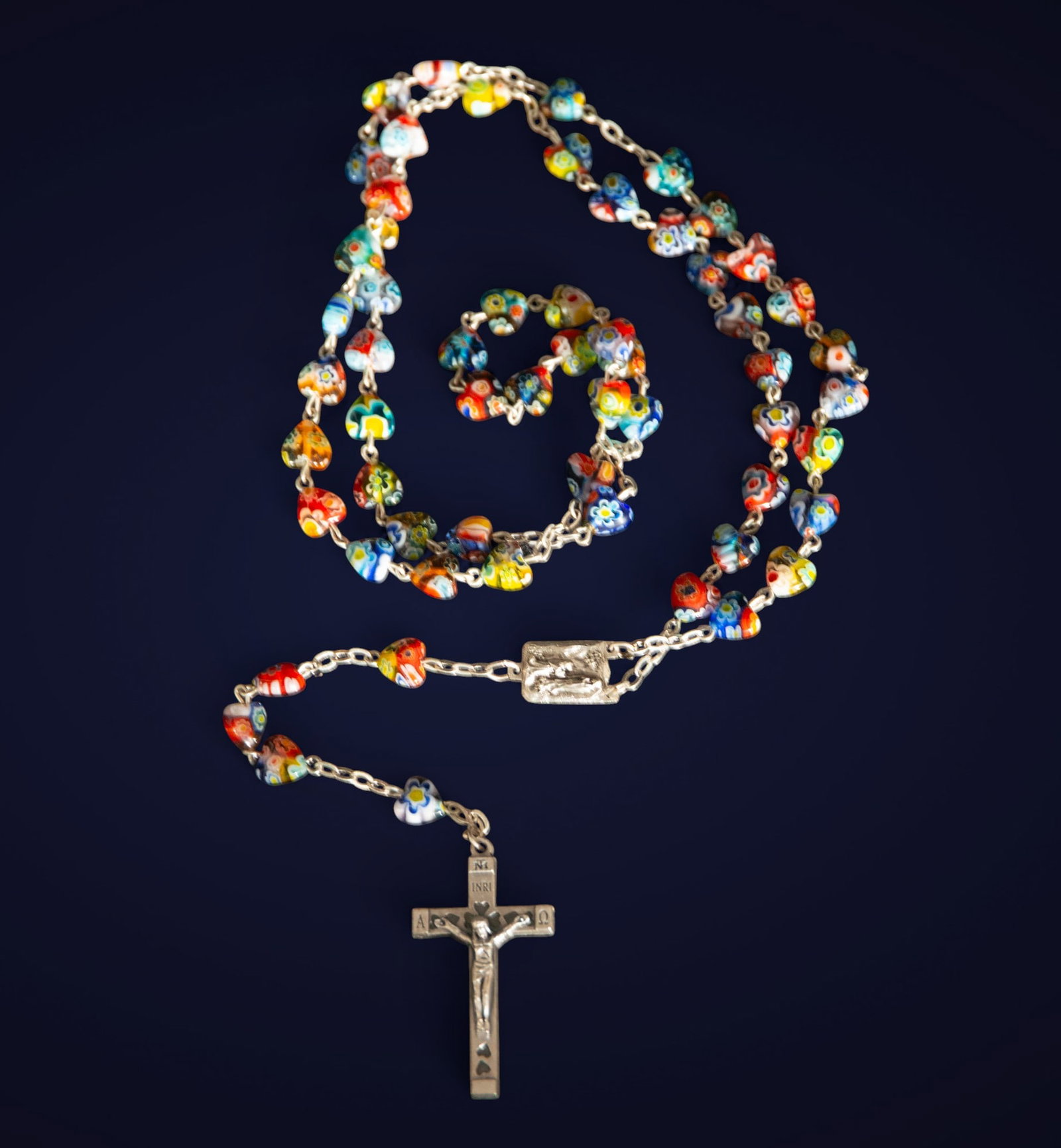 Murano glass rosary. Italian School. 20th century: Murano glass and metal. Measurements: 4 x 3 x 1 cm. Rosary made of multicolored Murano glass beads, worked using the millefiori technique, attached to a metal crucifix. The vibrant colors and rich orn