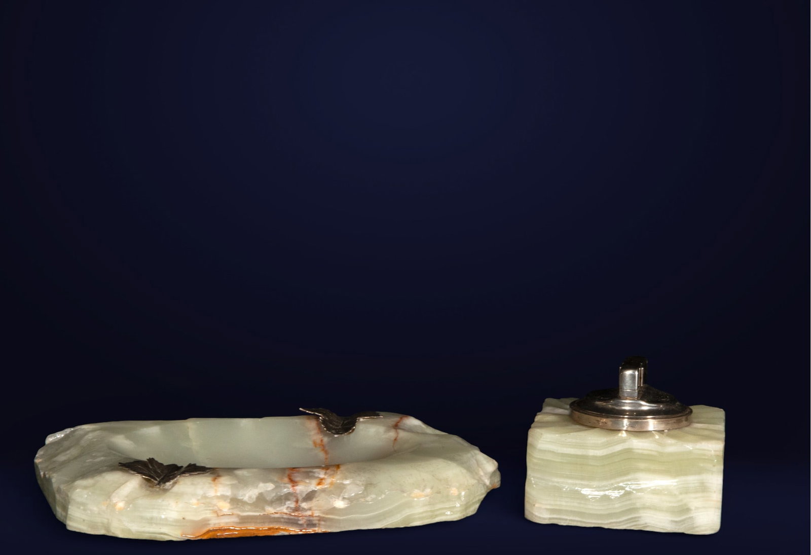 Desk set in onyx and silver. 19th century.: Ashtray and lighter set made of veined green onyx with silver accents. Dimensions: 9 x 8 x 8 cm and 37 x 20 x 16 cm. Elegantly handcrafted pieces with zoomorphic details in relief. An example of late 