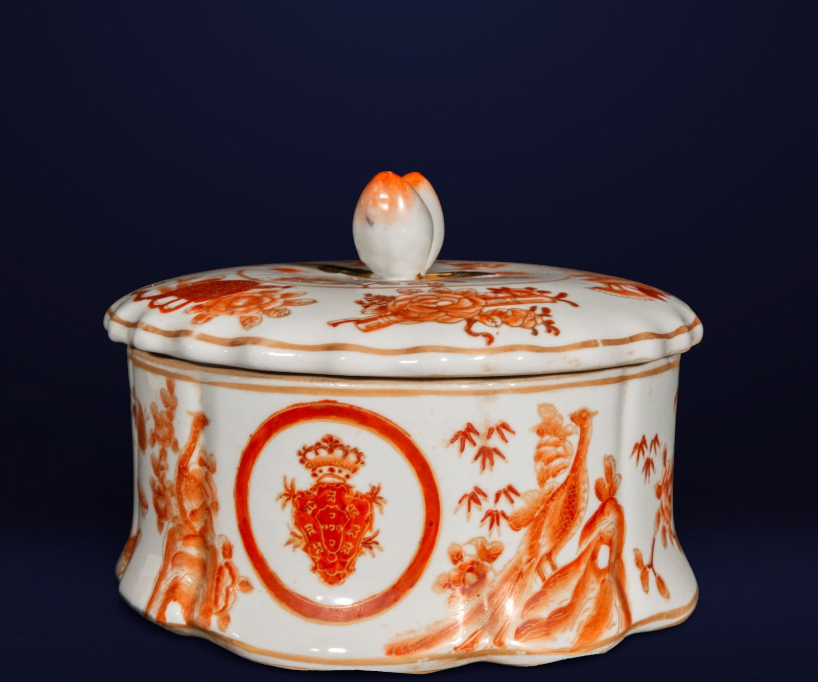 Chinese porcelain candy dish with coats of arms and decorative scenes. Chinese school. 20th century.: Oval bonbonnière in Chinese porcelain decorated in orange tones with heraldic motifs, birds, and female figures. Dimensions: 16 x 19 x 19 cm. An example of porcelain exported from Republican China.