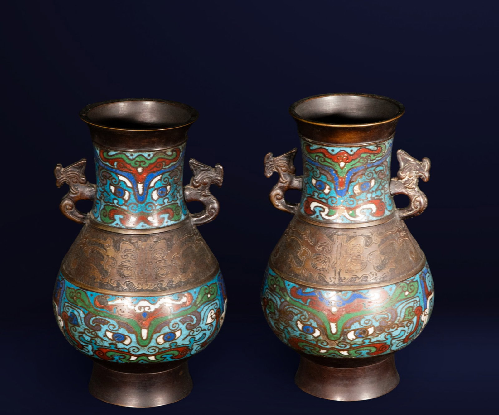 Pair of bronze and cloisonné enamel vases with stamp. Japanese school. Meiji period, 19th century.: Pair of ornamental vases in bronze and polychrome cloisonné enamel, with zoomorphic handles and geometric and floral decoration. Dimensions: 31 x 20 x 17 cm. An outstanding example of the Japanese Me