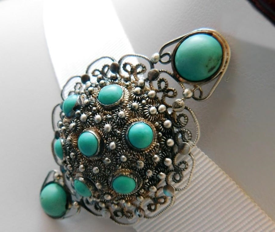 Antique Chinese filigree brooch, weight 12.5 g: Antique Chinese brooch, circa 1930, crafted in delicate silver filigree with an openwork design and decorated with nine cabochon turquoise stones. Hallmarks are intact. Weight: 12.5 g.