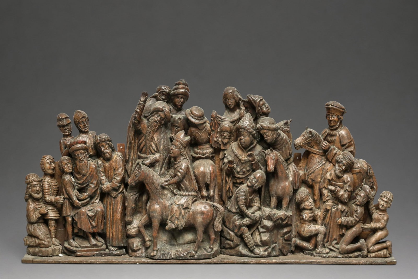 Monumental Late Medieval German Relief Group, Lower Rhine, 15th - 16th Century: Carved oak. Measures 86.5 x 188 cm. Altarpiece composed of four sculptural groups: in the center, Saint Veronica holds the veil revealing the face of Christ; next to her appears a bishop on horseback 