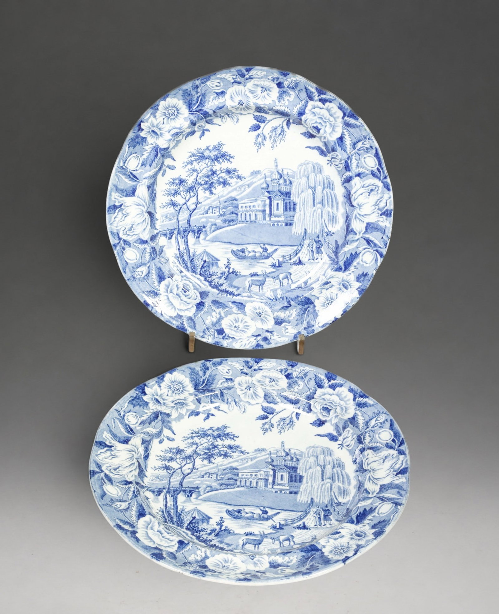 Pair of armorial plates in blue and white faience, France or Italy, 18th century: Tin-gilt faience painted in blue. Measures 25 cm in diameter. Pair of circular plates with blue camaieu decoration. The center features a crowned armorial shield framed by mantling within a medallion,
