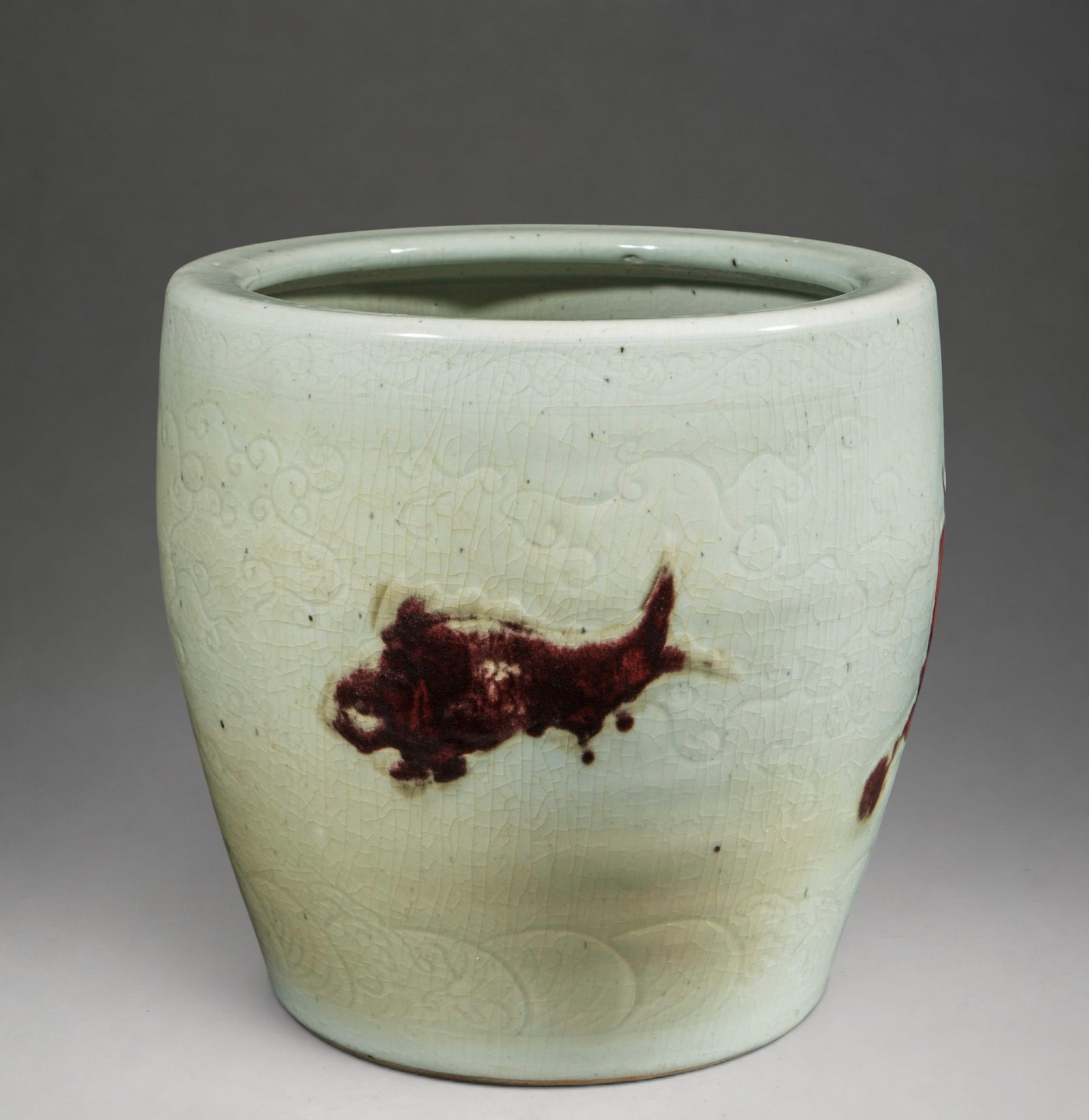 Antique Chinese Fishbowl, Qing Dynasty, 18th Century: Crackled glazed porcelain with copper-red decoration. Measures 33.5 x 33.5 cm. Cylindrical vessel with high walls decorated with red enamel fish on a creamy white background. The surface exhibits wide