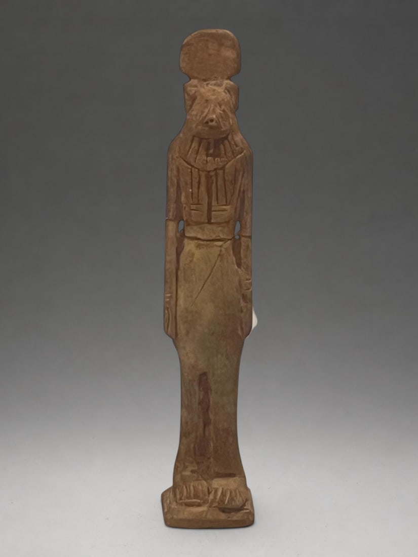 Statuette of Anubis, Egypt Late Period, 7th-6th century BC.: Carved bone with natural patina and dark residue. Measures 10.5 cm in height. Statuette of Anubis with a jackal's head, elongated snout, triangular ears, and frontal body. The figure wears an incised 