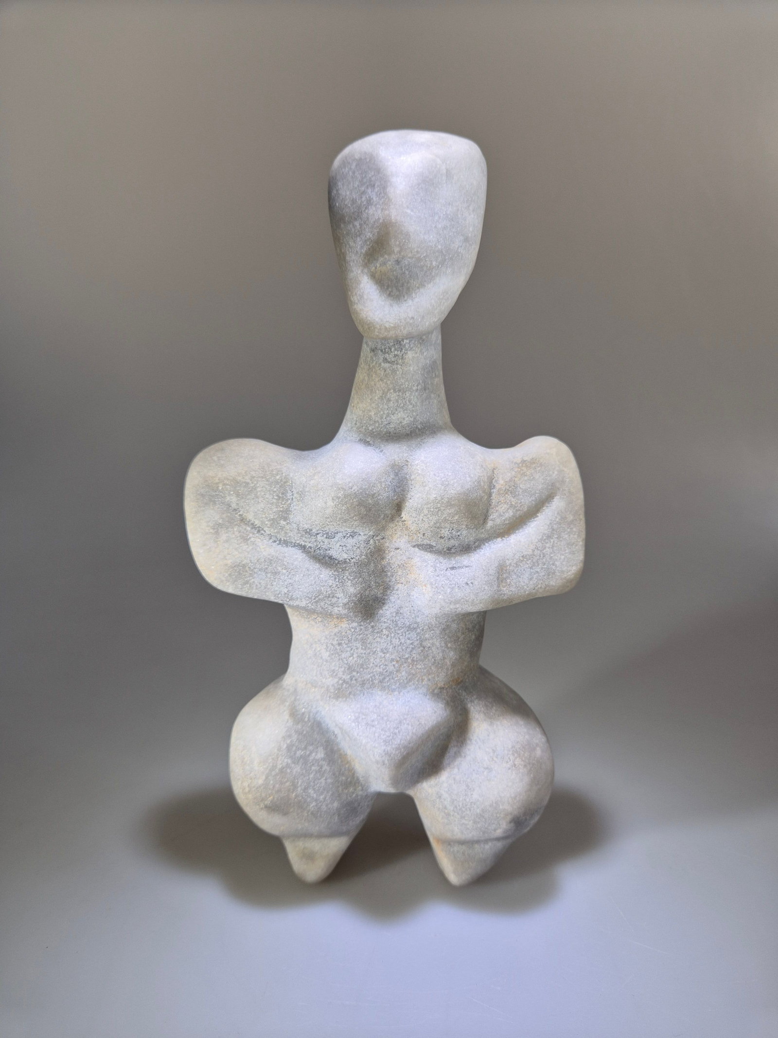 Neolithic steatopygous female figurine no. 3, 5th-4th millennium BC, eastern Mediterranean region /: Grayish-white marble. Measurements: approx. 20 cm high; weight: approx. 776 g. Steatopygous female figure with a schematic head, arms placed across the chest, and accentuated body volumes, following m