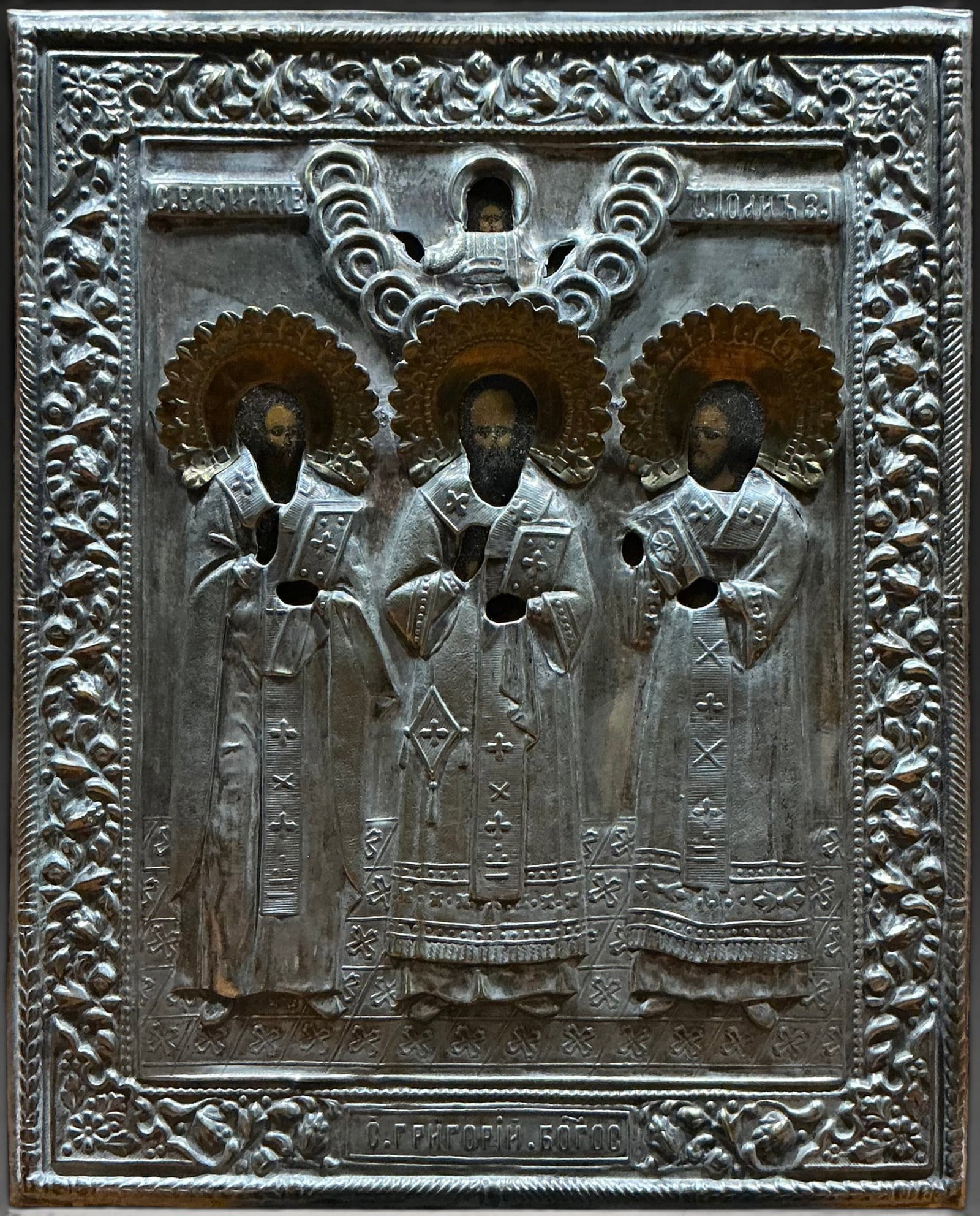 Deesis icon with Christ and three saints, Russian School, 19th century: Tempera on panel covered with chased metal oklad. Measures 22.3 x 17.8 cm. Icon with three standing saints under a repoussé metal covering decorated with vegetal and geometric motifs. The figures are
