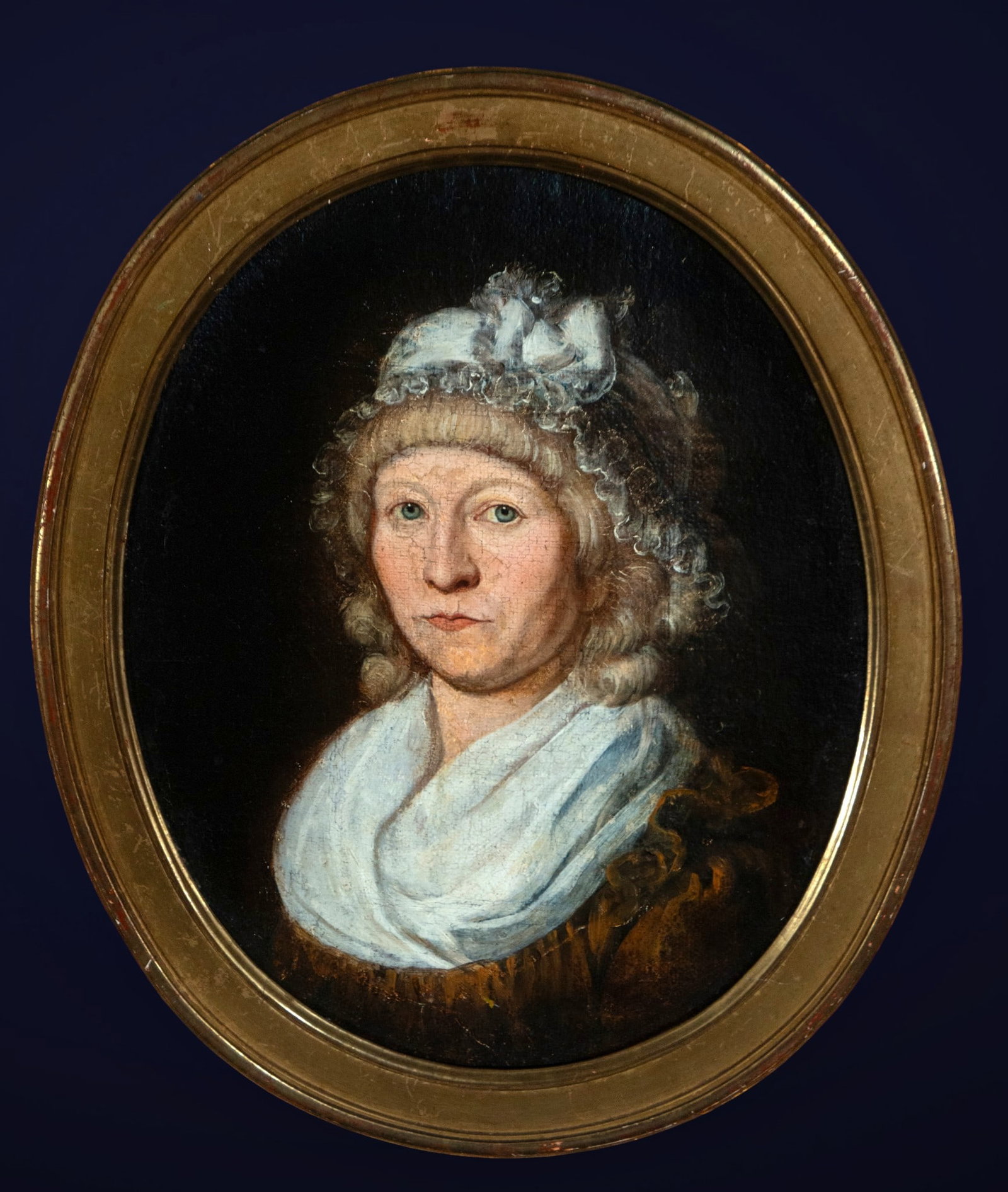 Portrait of a lady with a headdress, European School, 18th Century: Oil on canvas. A bust portrait of a woman, conceived with great restraint and psychological sensitivity, depicting her wearing a cap adorned with ribbons and a large white scarf draped over her should