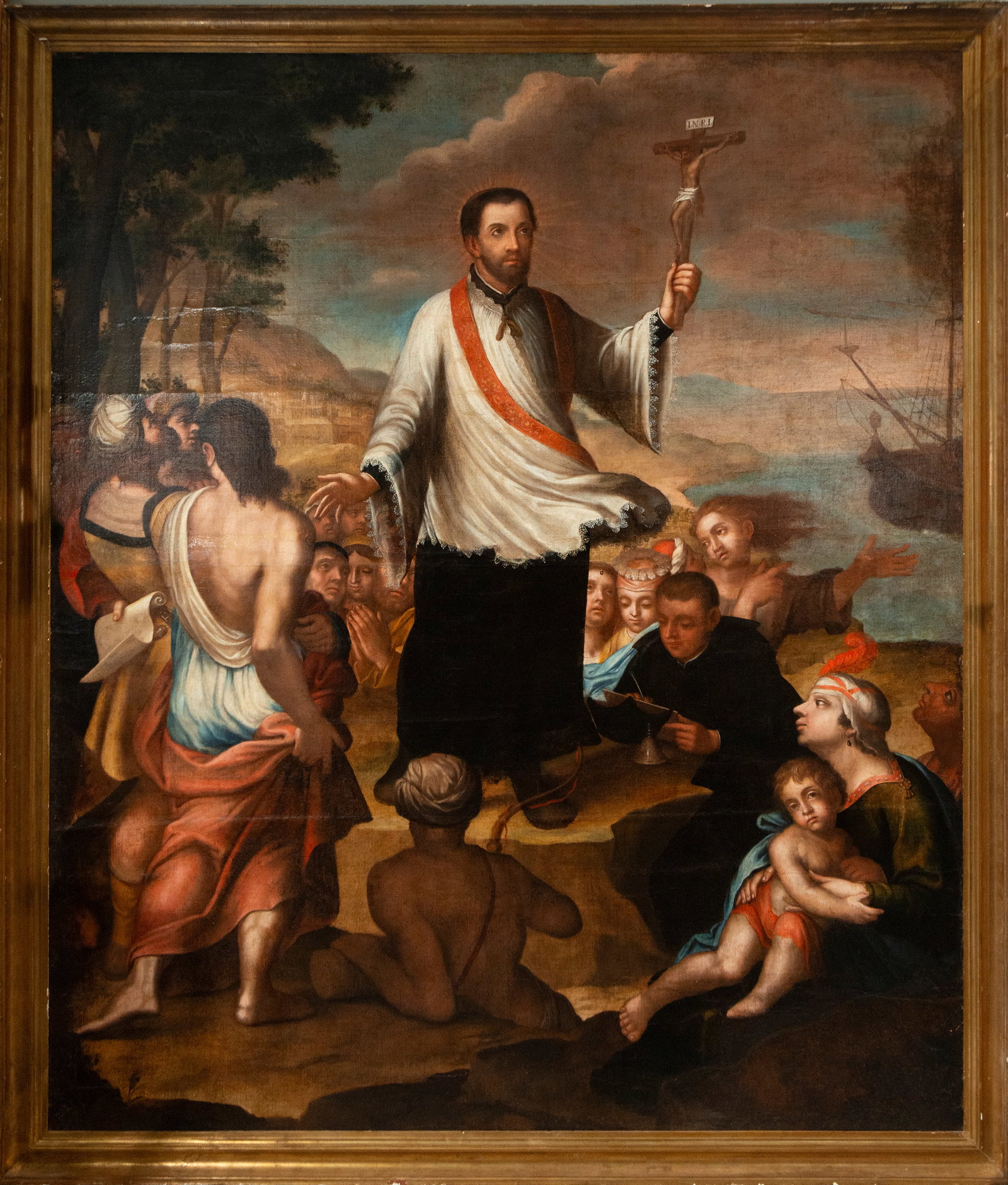 Saint Francis Xavier evangelizing in Goa, attributed to Jérôme Sourlay, Colonial French School,: Oil on canvas. A monumental composition of a missionary and devotional nature, centered on the figure of Saint Francis Xavier, depicted standing on a rocky rise while holding a raised crucifix as a sy