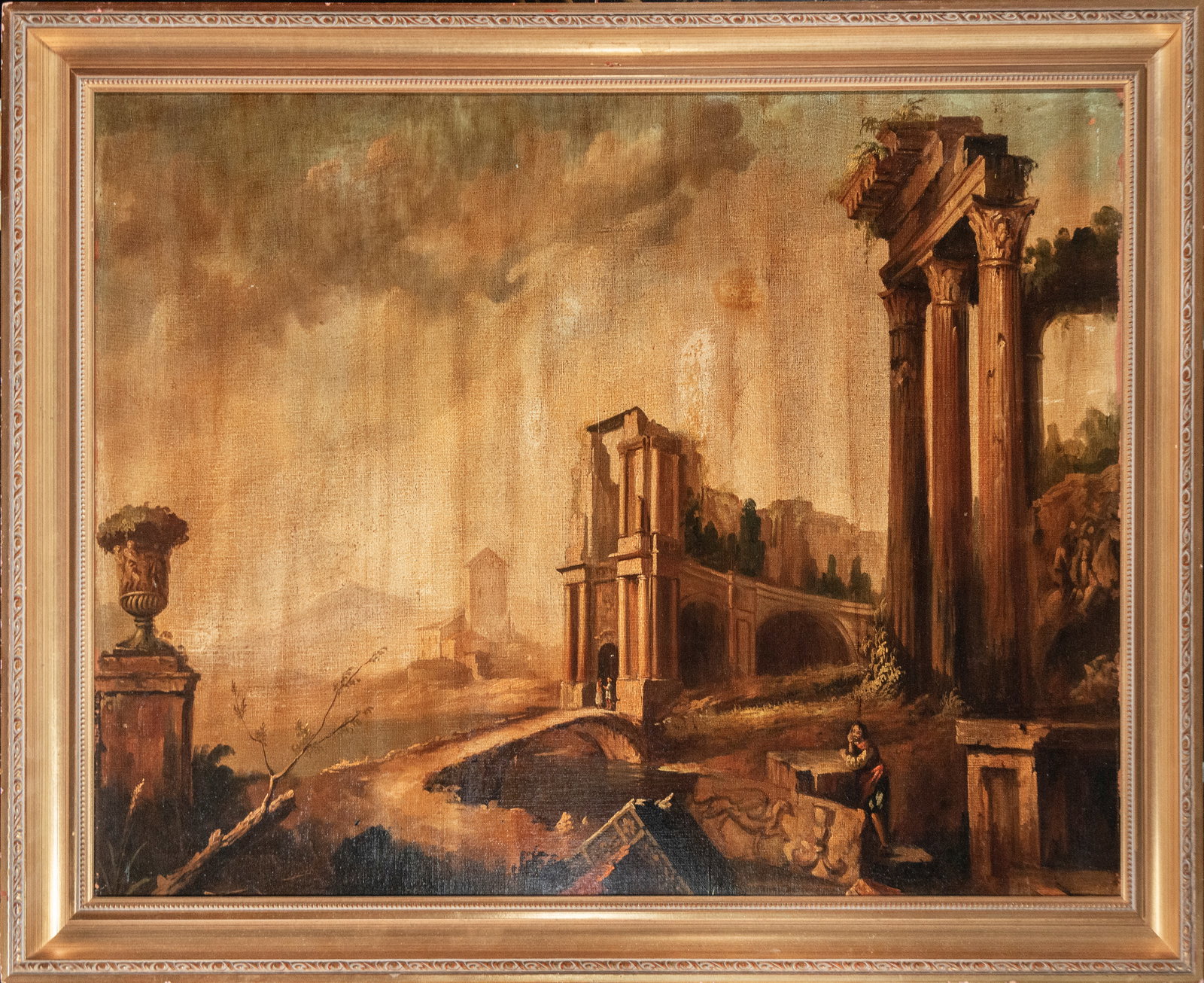 Architectural Capriccio with Classical Ruins, Italian School, late 18th Century: Oil on canvas. An elegant, whimsical architectural landscape where monumental classical ruins rise alongside a bridge and idealized buildings in a wide, open setting with a melancholic atmosphere. The
