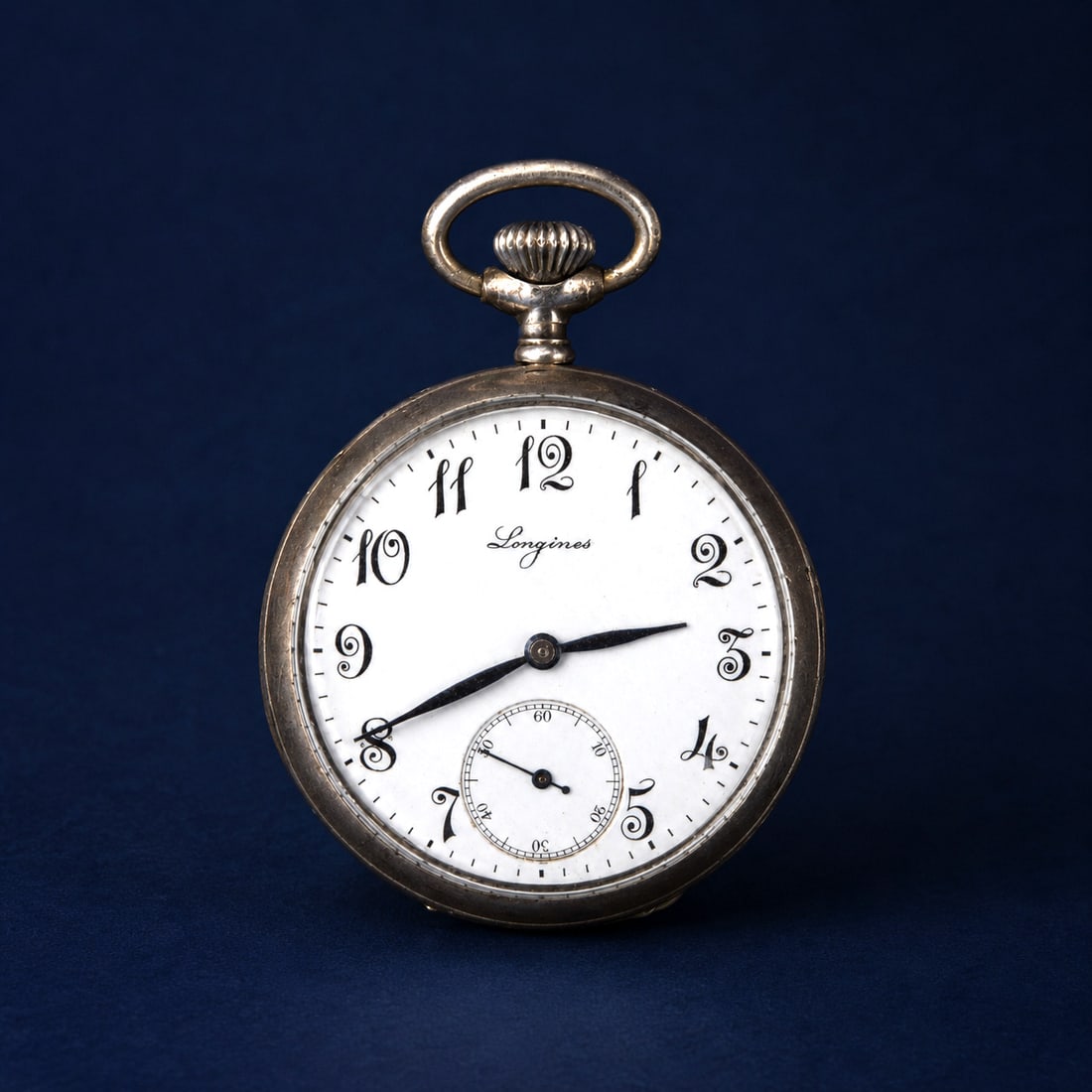 Longines silver watch, Swiss School, 19th century: Silver and enamel. Dimensions: 6 x 4 x 1.5 cm. Longines pocket watch with a silver case and white enamel dial featuring stylized numerals and a subsidiary seconds hand. The design is notable for the e
